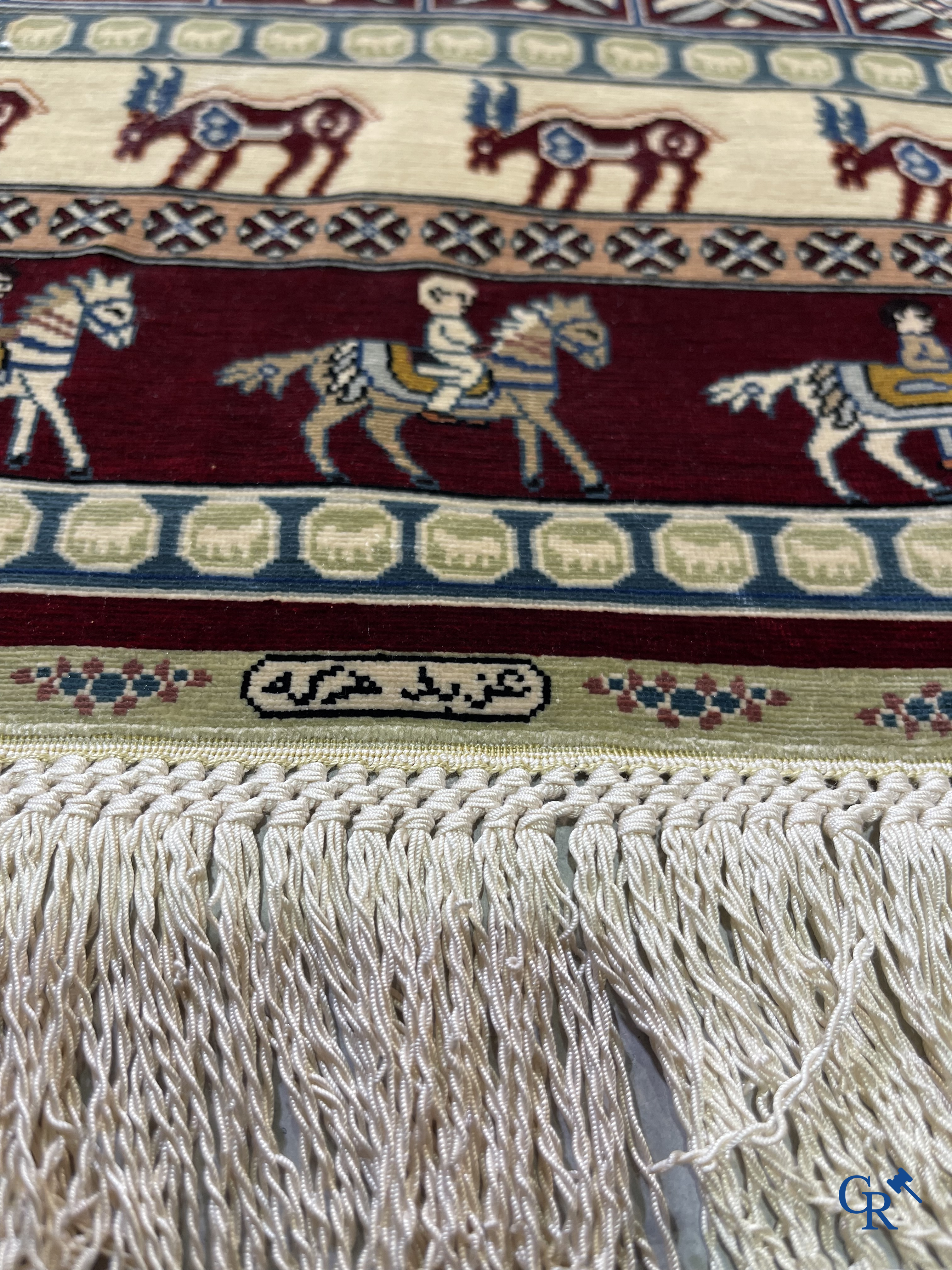 Oriental rugs: A small finely hand-knotted silk rug with deer and horsemen. Signed.