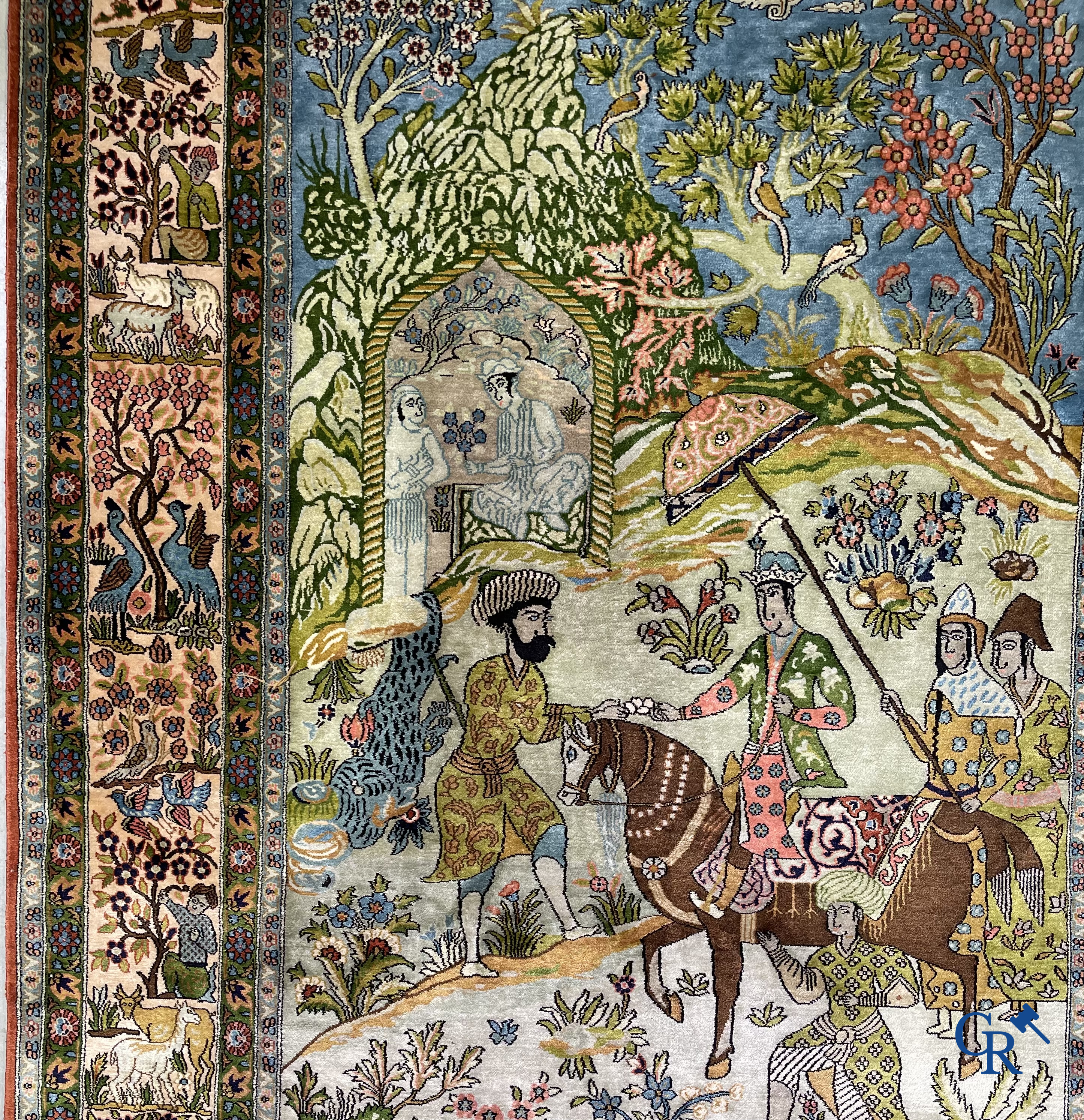 Tapis d'Orient. Iran. Un tapis persan en soie finement noué à la main avec des personnages et un cheval dans un paysage.