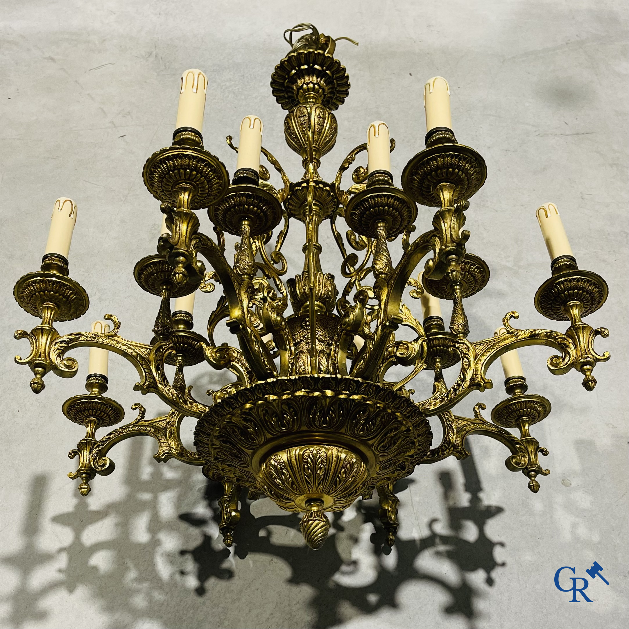 Un grand lustre en bronze avec 16 points lumineux et une applique murale assortie.