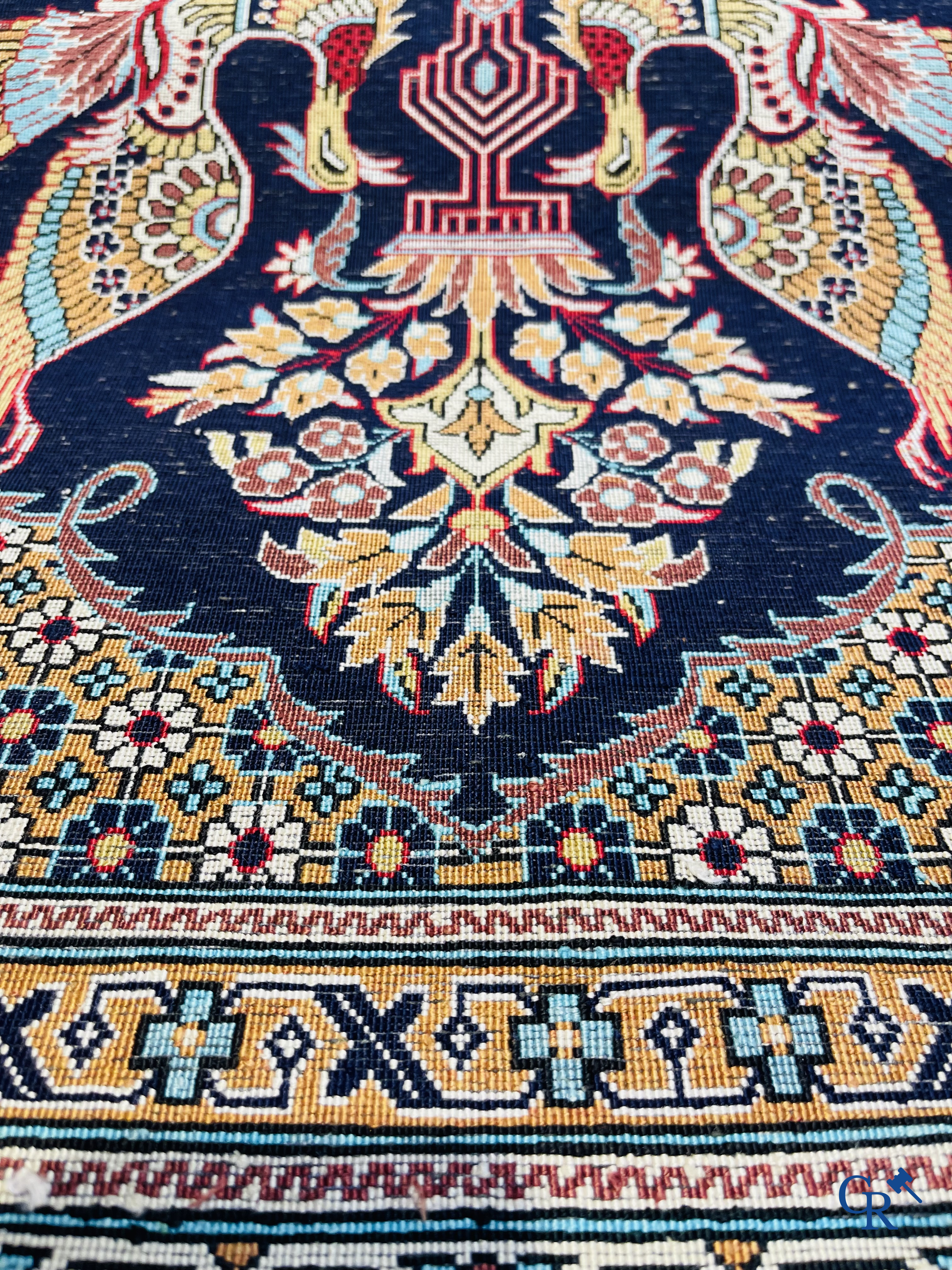 Persian carpets: A finely knotted silk Ghoum carpet with a decor of birds and flowers.