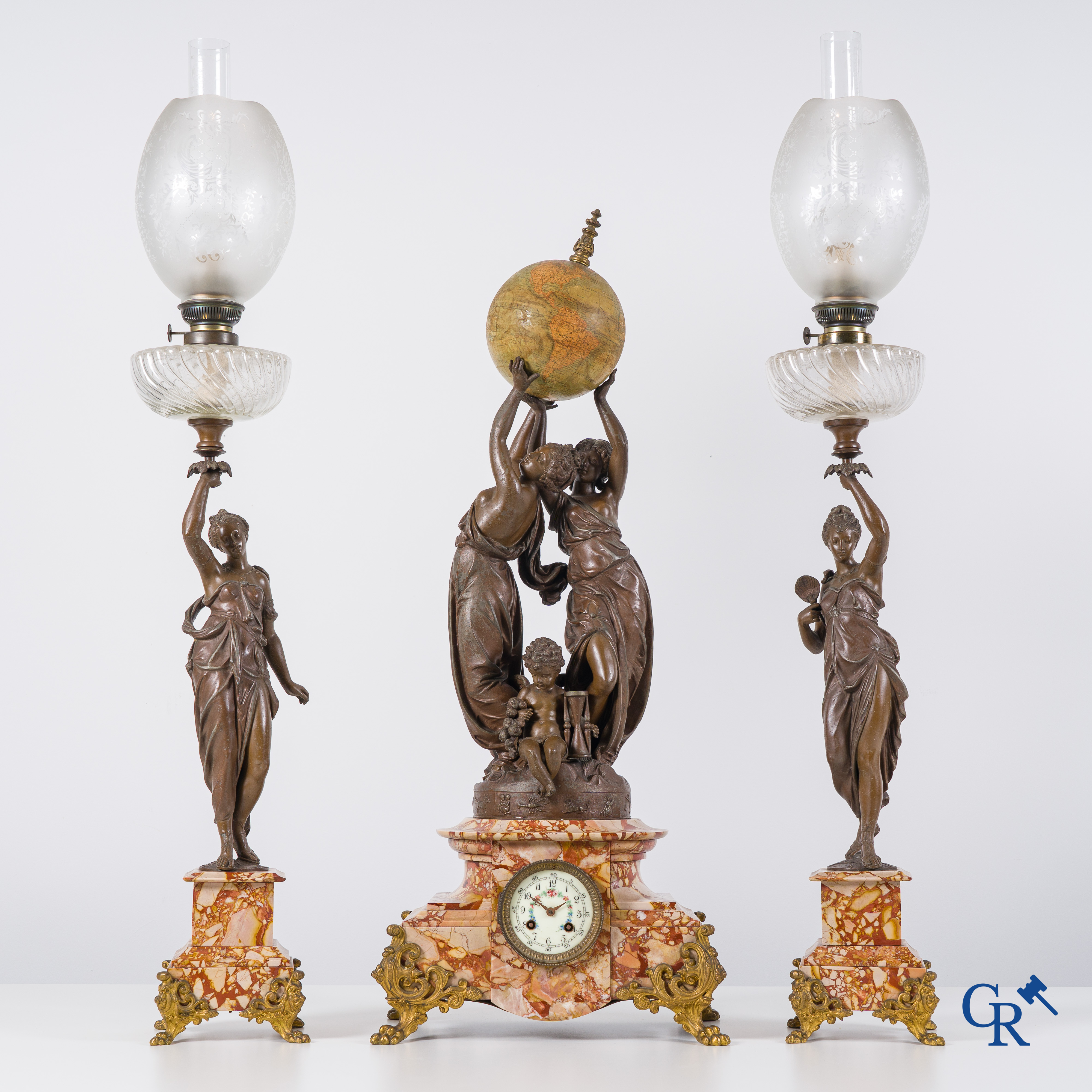 An imposing clock set in marble and spelter, signed Petit, petroleum lamps with glassware in the manner of Baccarat.