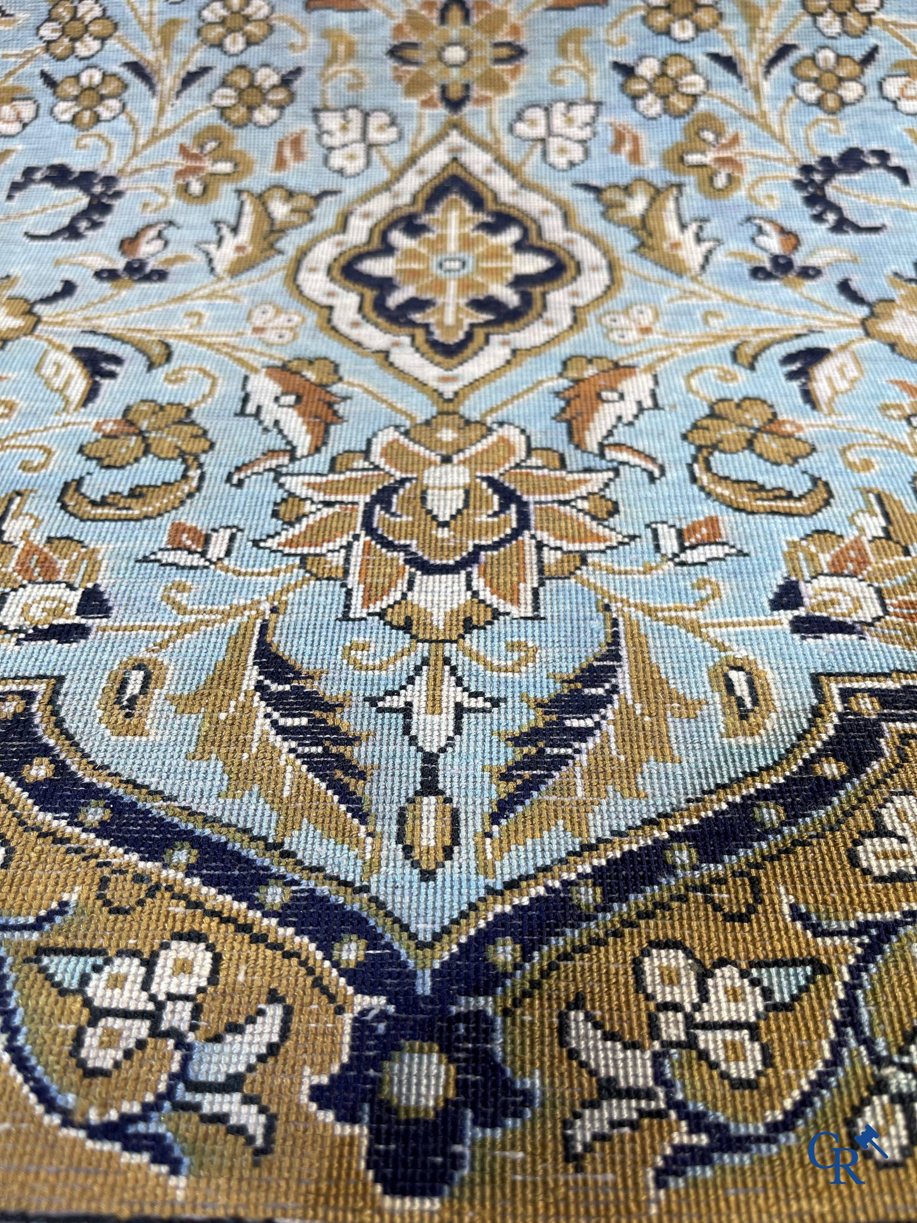 Tapis d'Orient. Un tapis en soie finement noué à la main avec un décor floral.