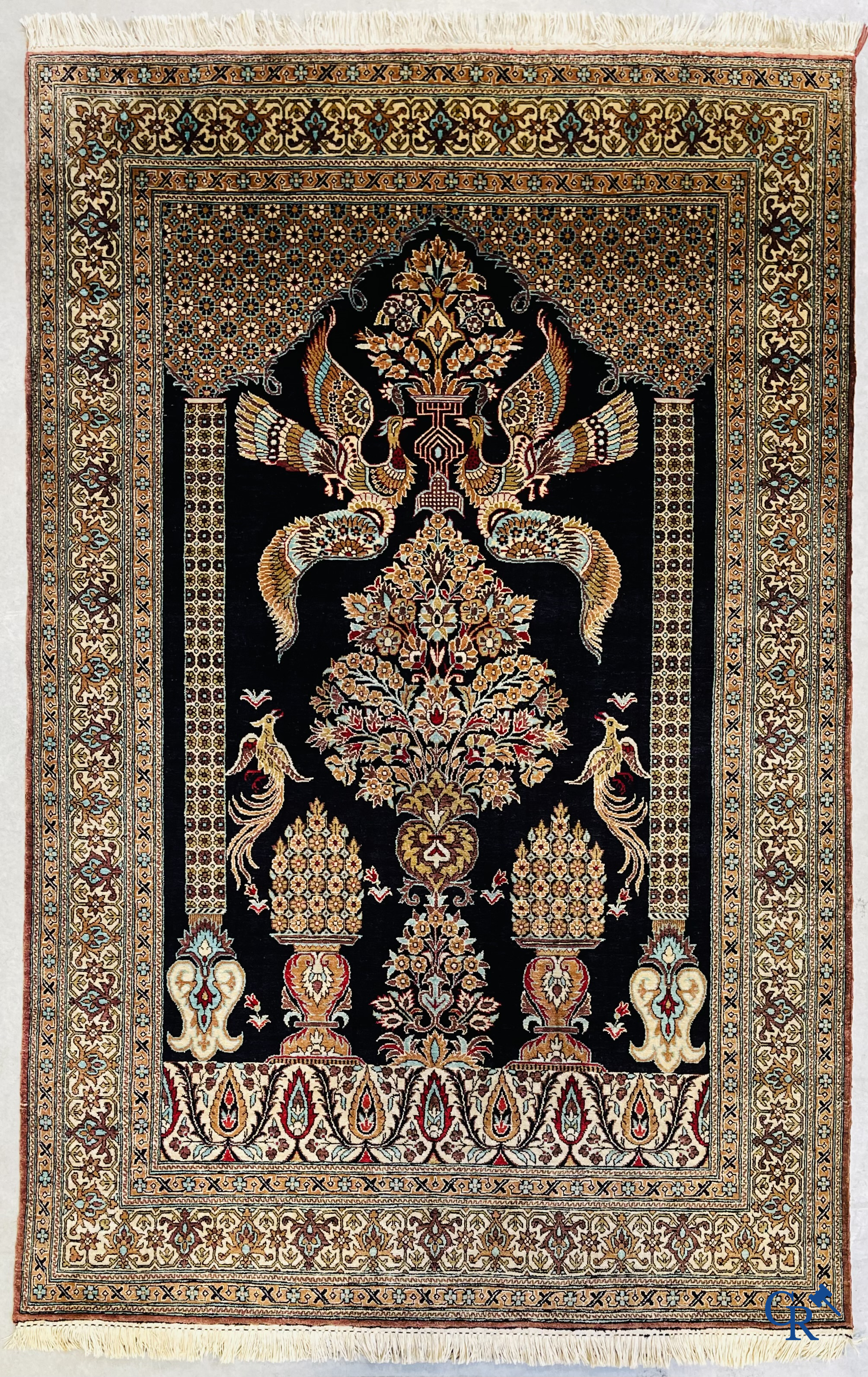 Persian carpets: A finely knotted silk Ghoum carpet with a decor of birds and flowers.