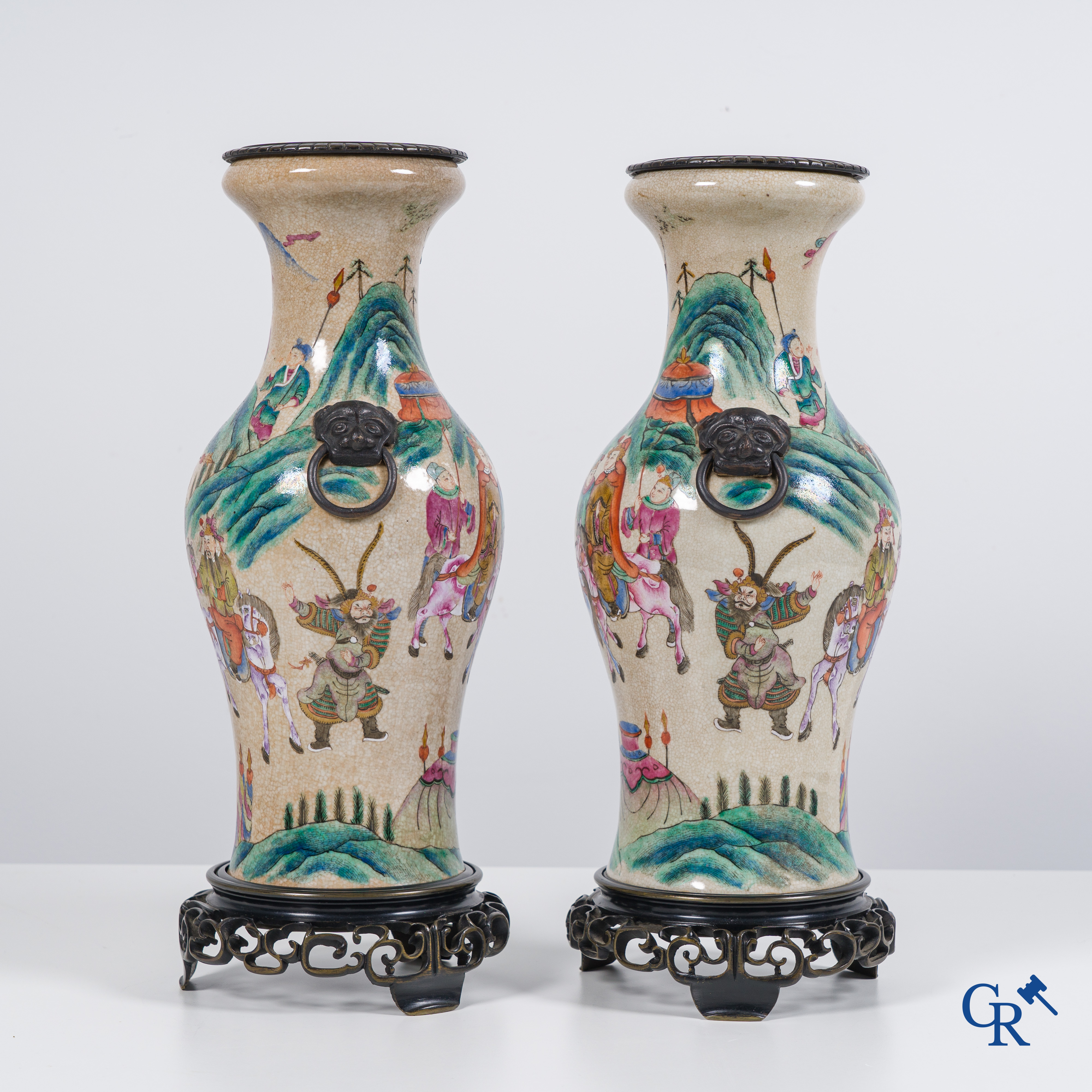 Asian Art: Chinese porcelain. A pair of finely decorated famille rose vases in a bronze frame. 19th century.