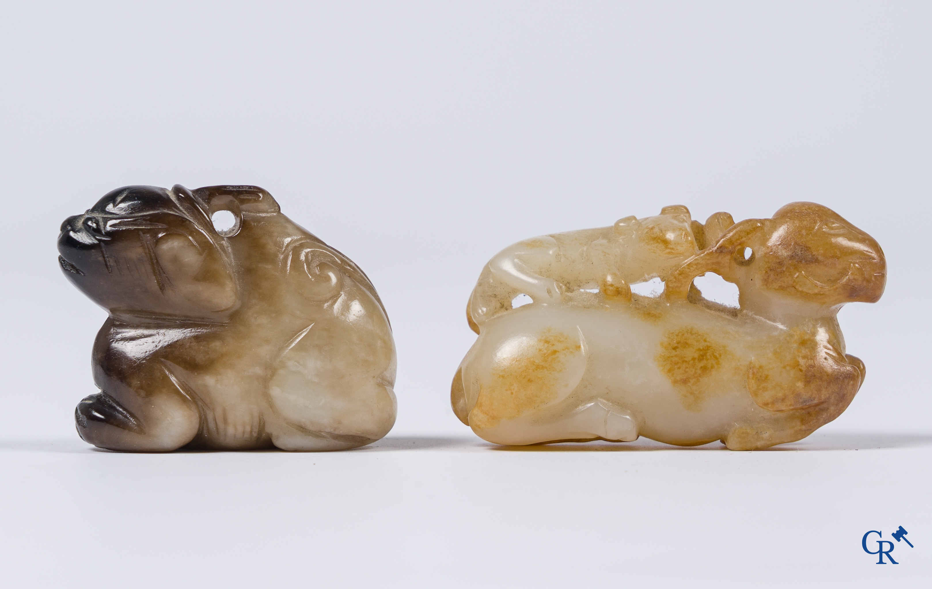 Aziatica. Een bleek celadon en roestbruin kleurige jade hertengroep en een bruinkleurig mythisch beest in jade.