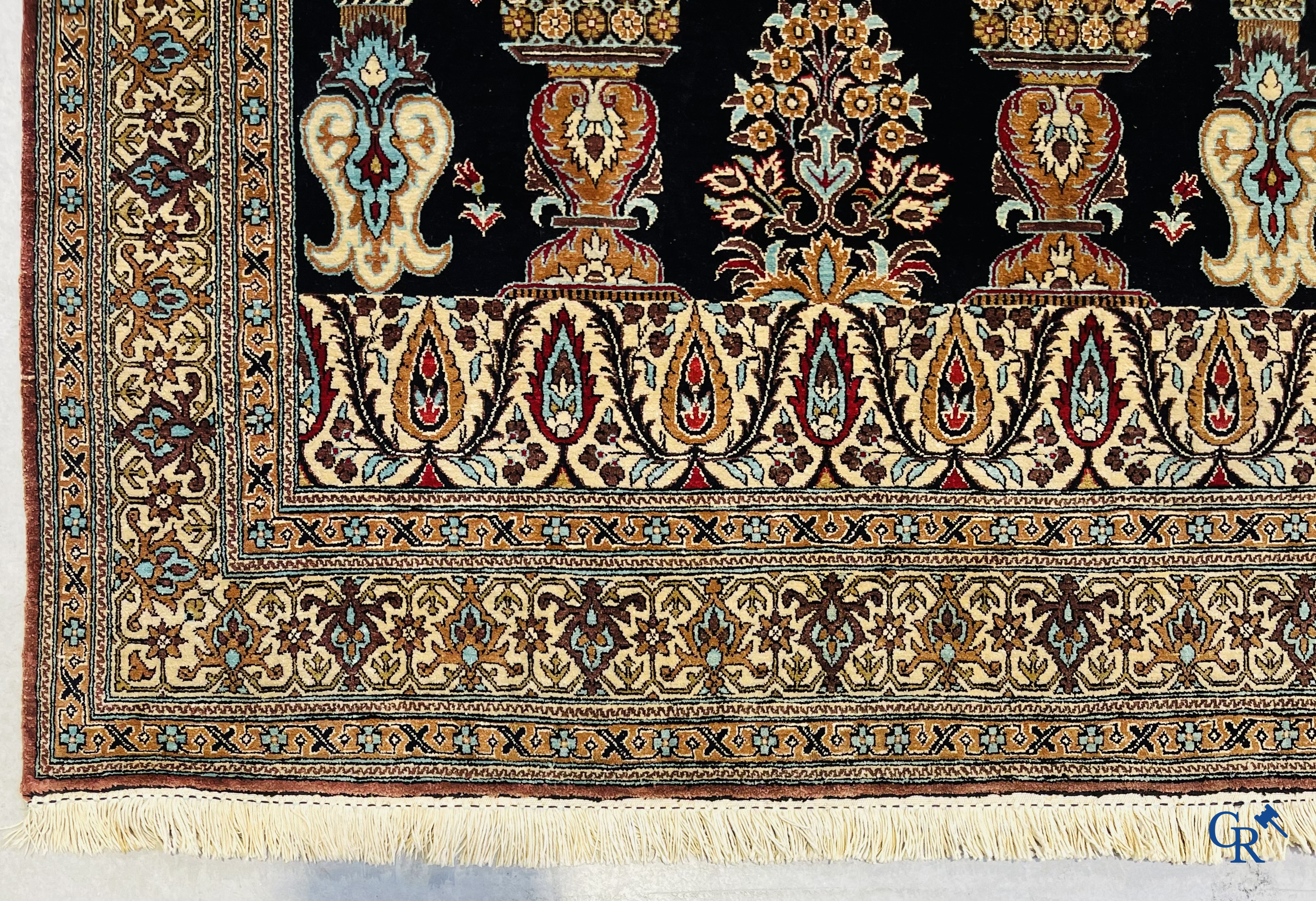 Persian carpets: A finely knotted silk Ghoum carpet with a decor of birds and flowers.