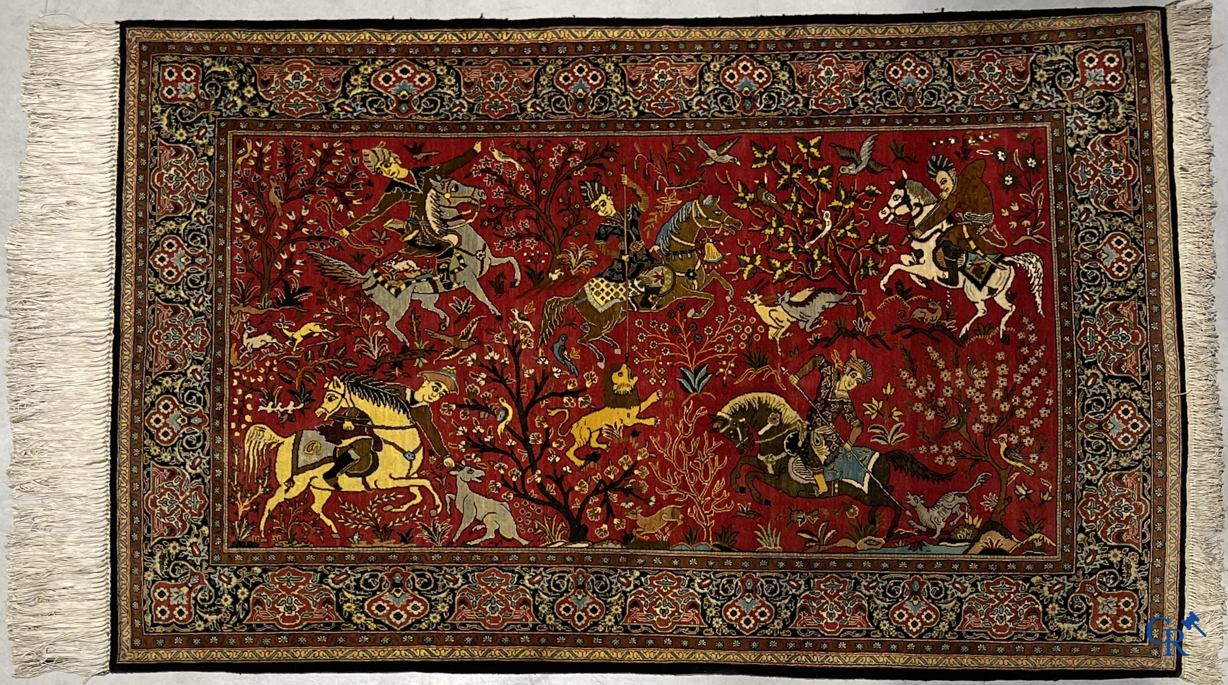 Oriental carpets, a Persian carpet in silk with a scene of hunters on horseback.