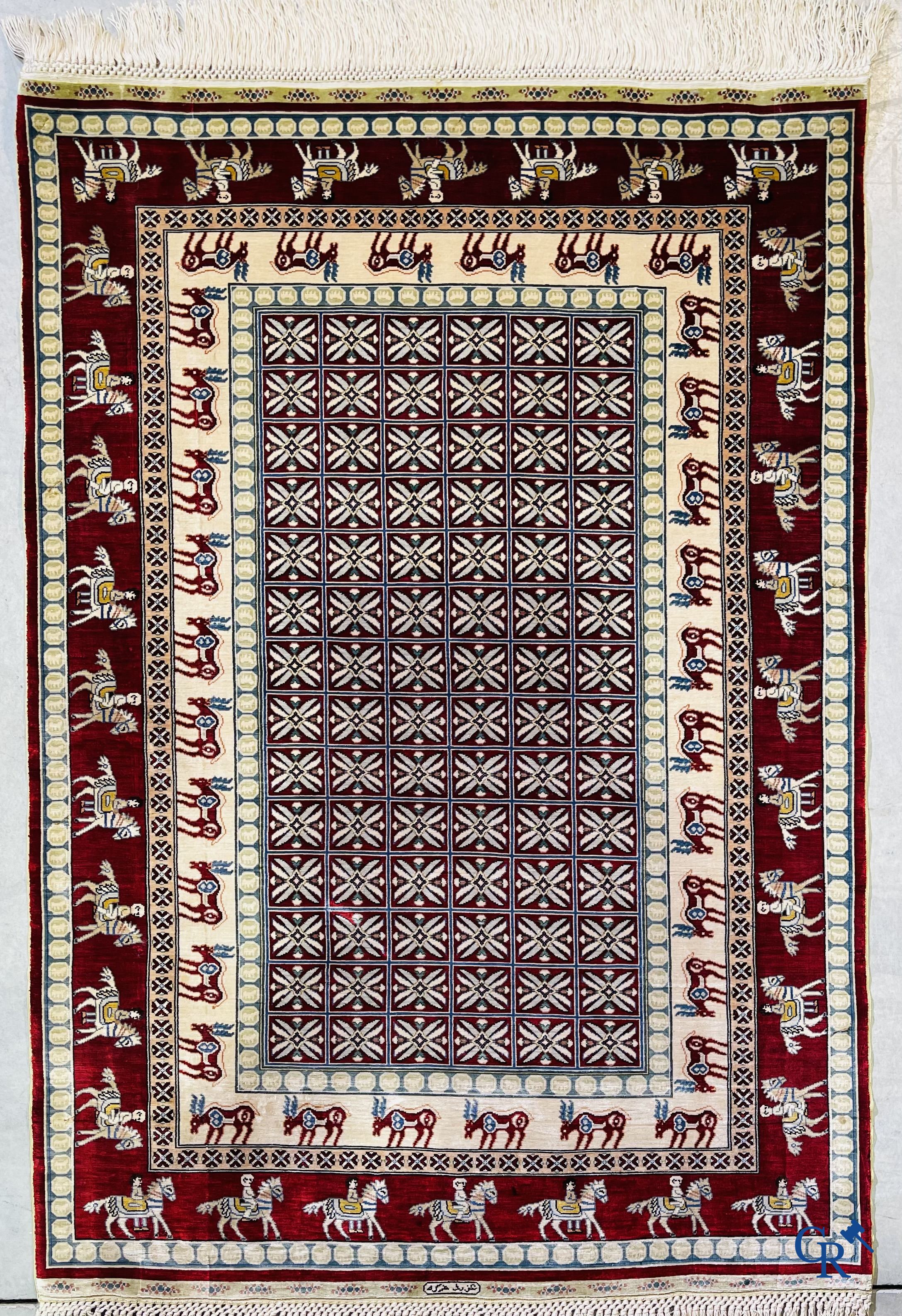 Oriental rugs: A small finely hand-knotted silk rug with deer and horsemen. Signed.