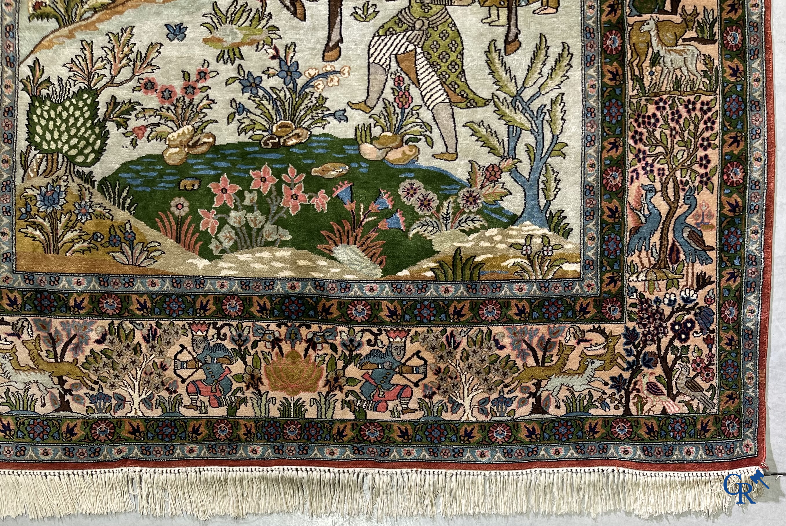 Tapis d'Orient. Iran. Un tapis persan en soie finement noué à la main avec des personnages et un cheval dans un paysage.