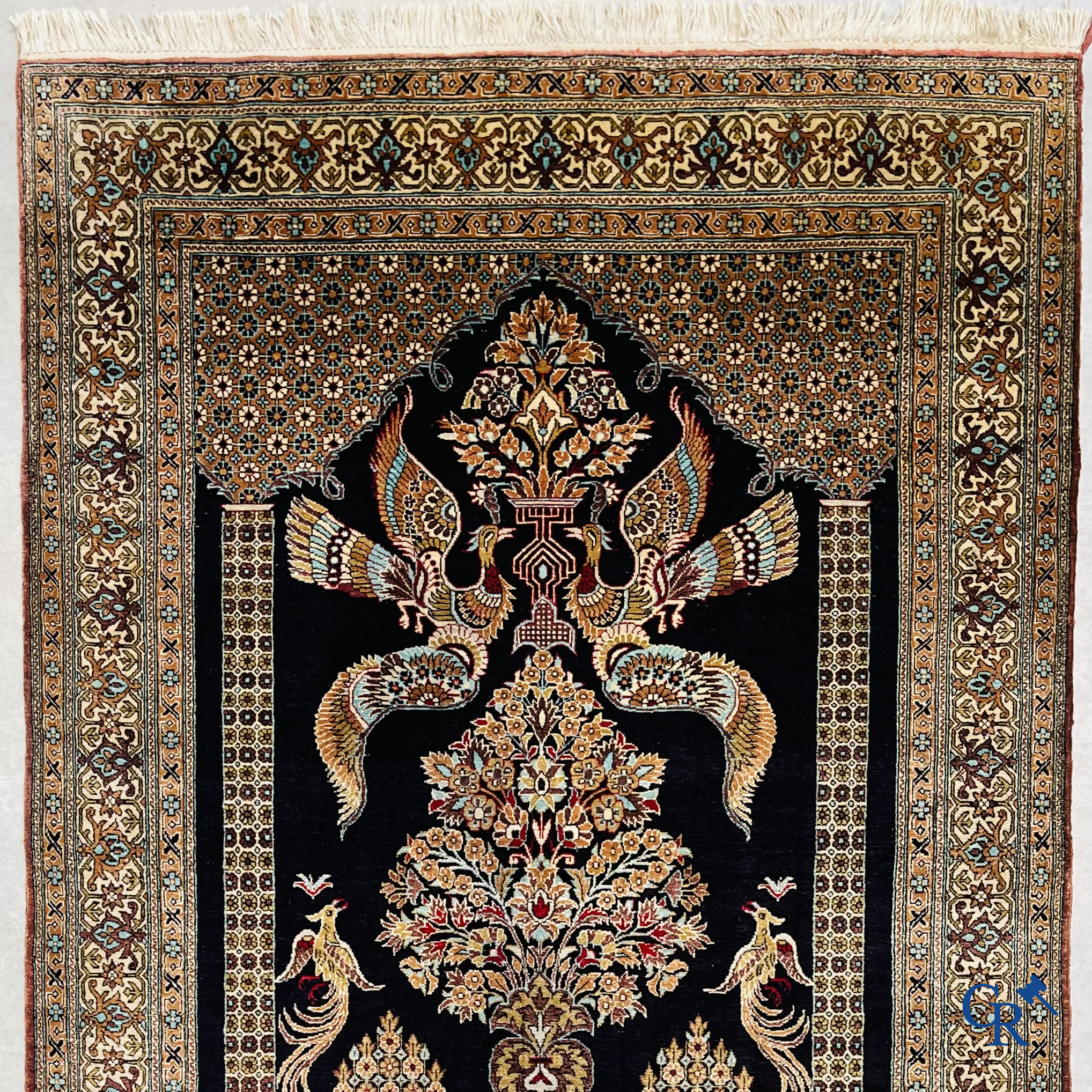 Persian carpets: A finely knotted silk Ghoum carpet with a decor of birds and flowers.