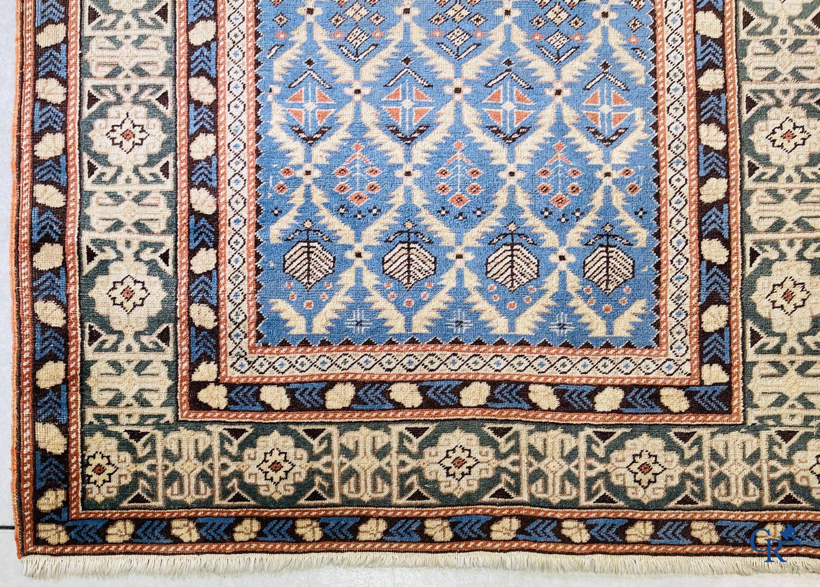 Antique Oriental carpets, an antique Dagestan carpet with motifs on a blue background.