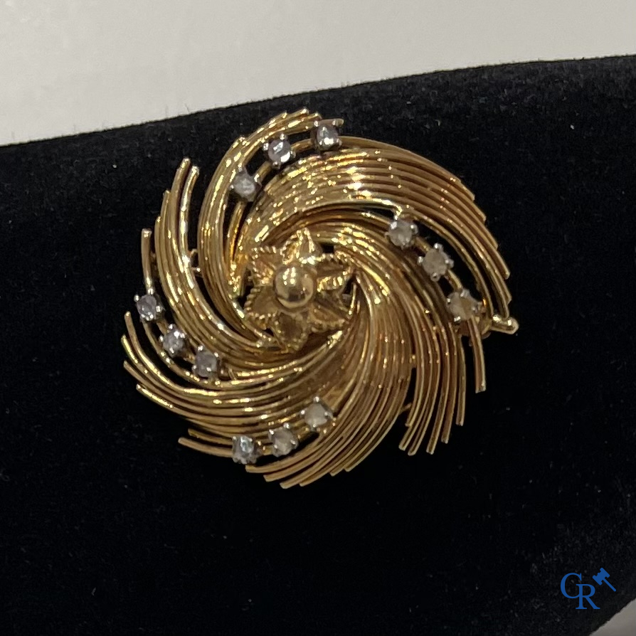 Juwelen, uurwerken, een broche in goud 750°/00 bezet met kleine briljanten.