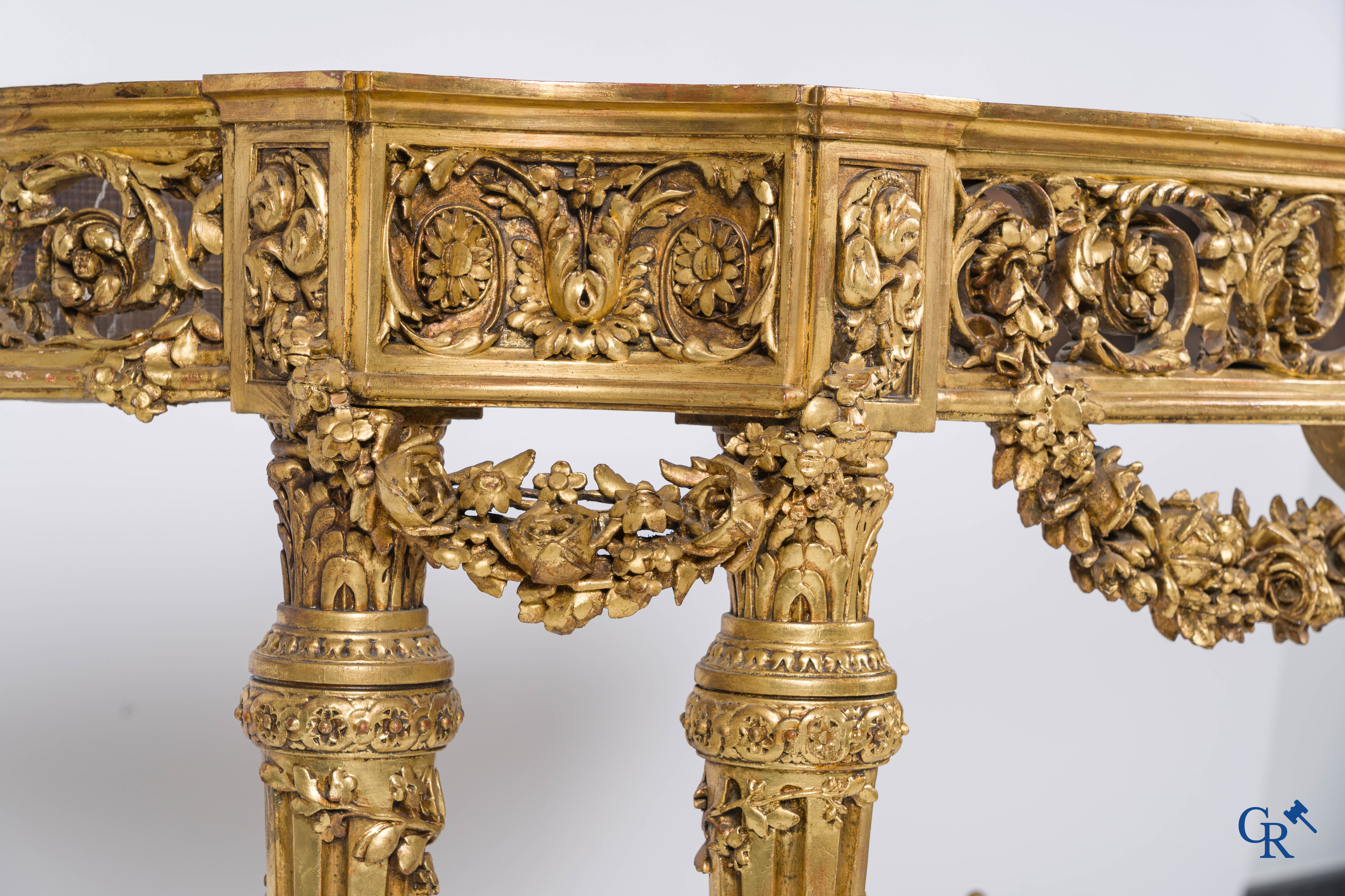 A richly carved and gilded console table in LVXI style with a grisaille painting on marble.