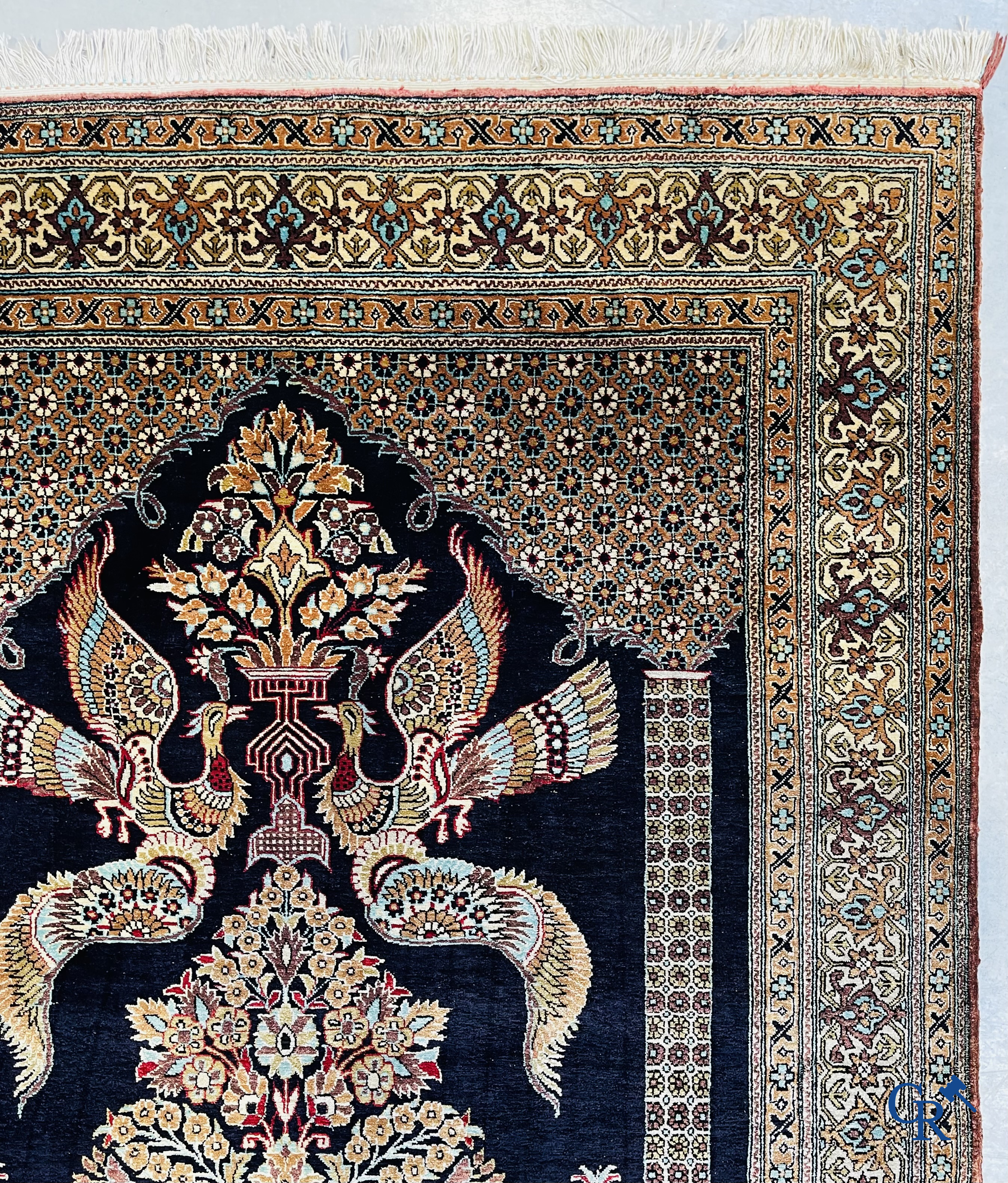 Persian carpets: A finely knotted silk Ghoum carpet with a decor of birds and flowers.