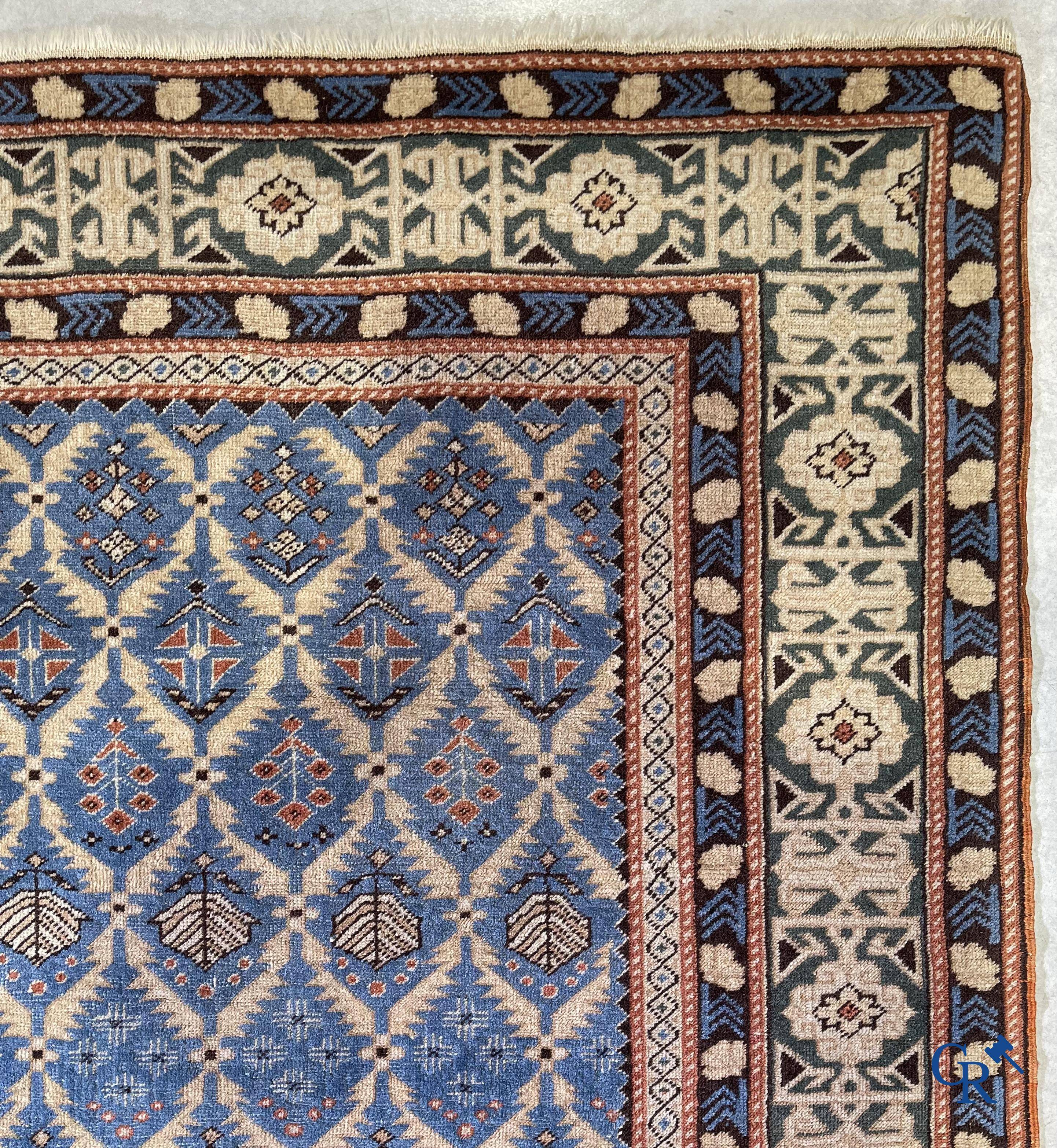 Antique Oriental carpets, an antique Dagestan carpet with motifs on a blue background.