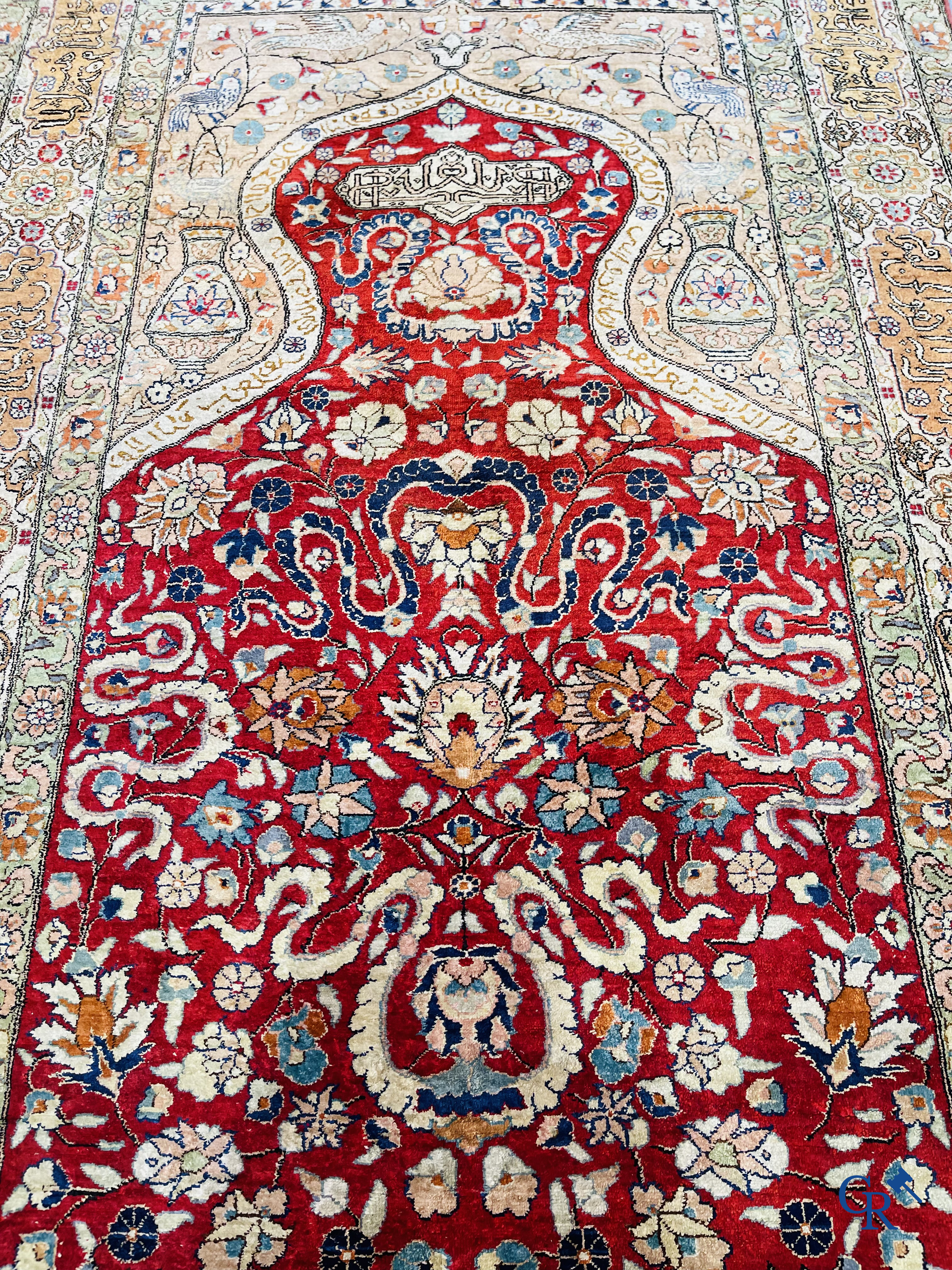 Oriental carpets: Hereke, a finely knotted silk carpet with inscriptions and birds in a floral decor.