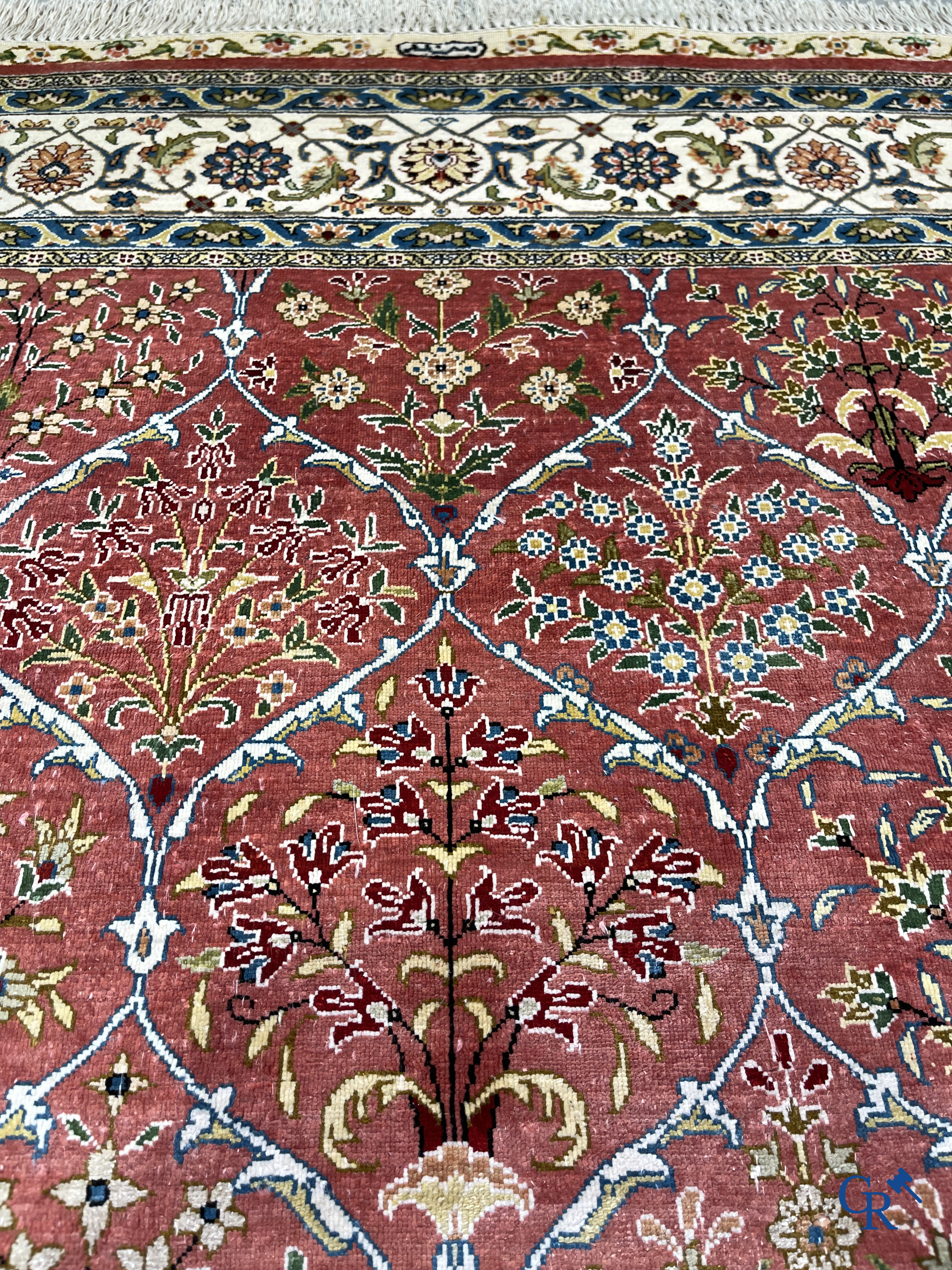 Tapis d'Orient: Un tapis finement noué à la main en laine et soie avec un décor floral.<br />
Signé.