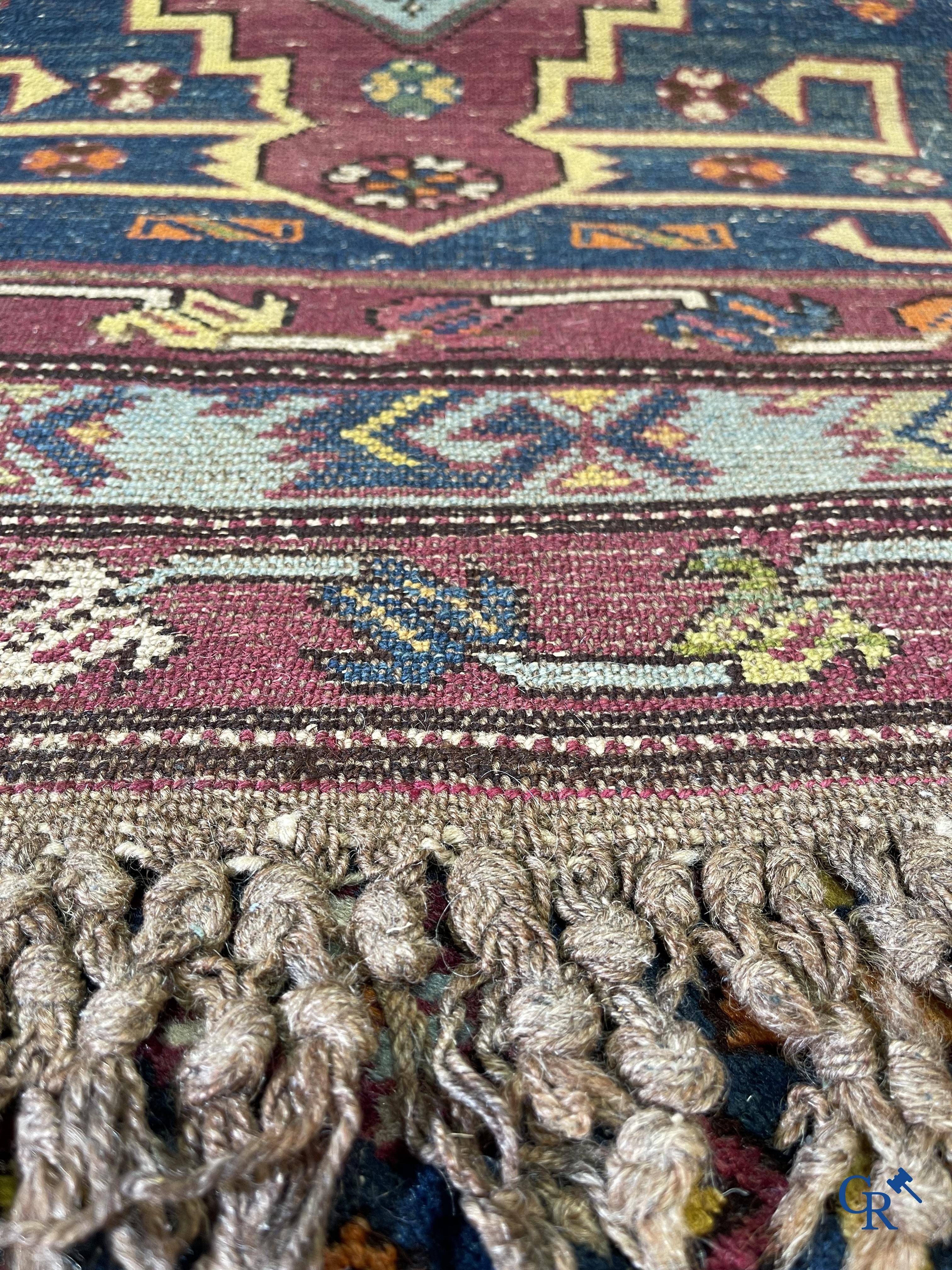 Oriental carpets, an antique hand-knotted Oriental carpet with motifs on a blue background.