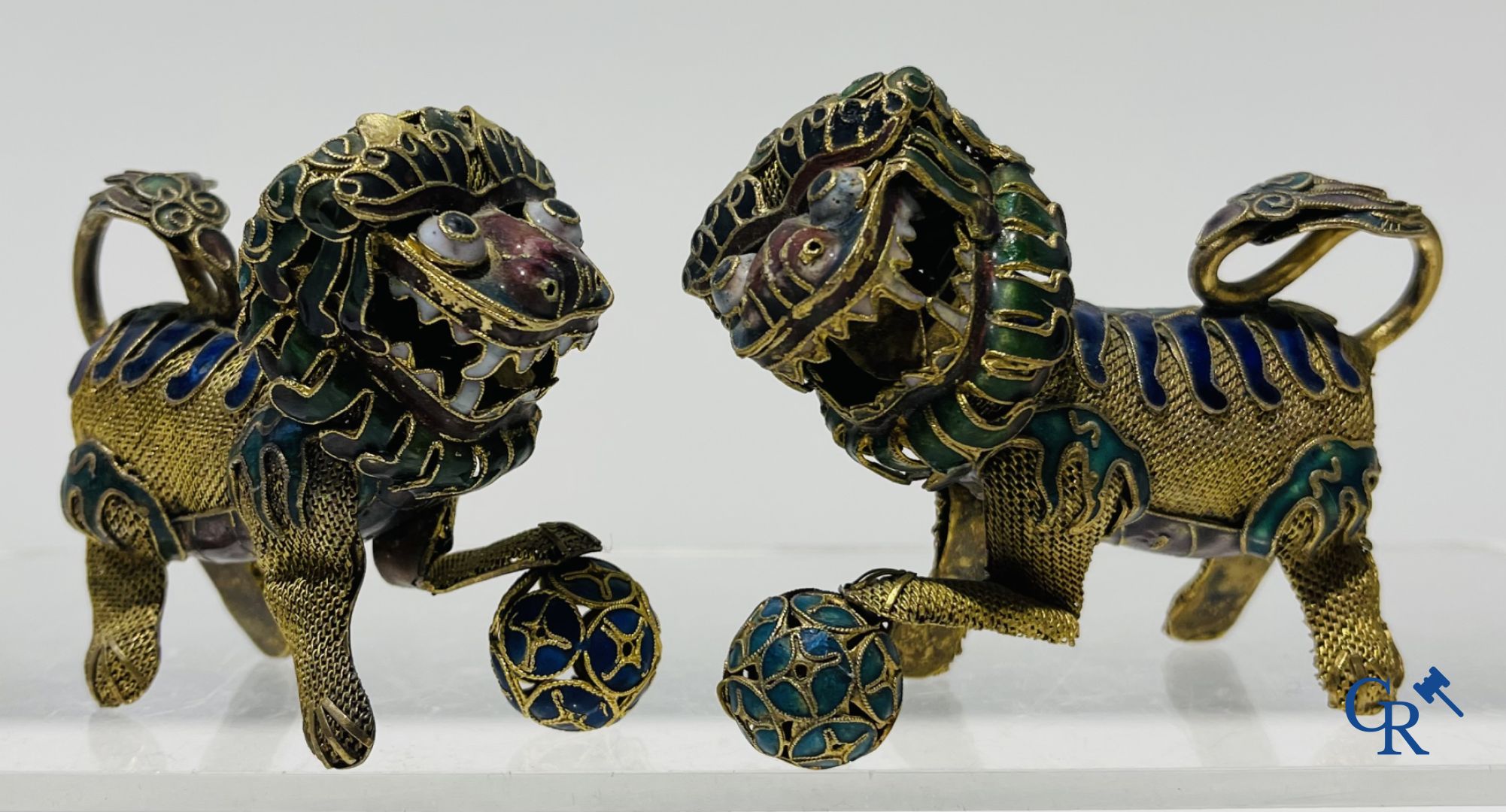 Un lot de divers objets en argent et une paire de lions bouddhistes en cuivre émaillé.