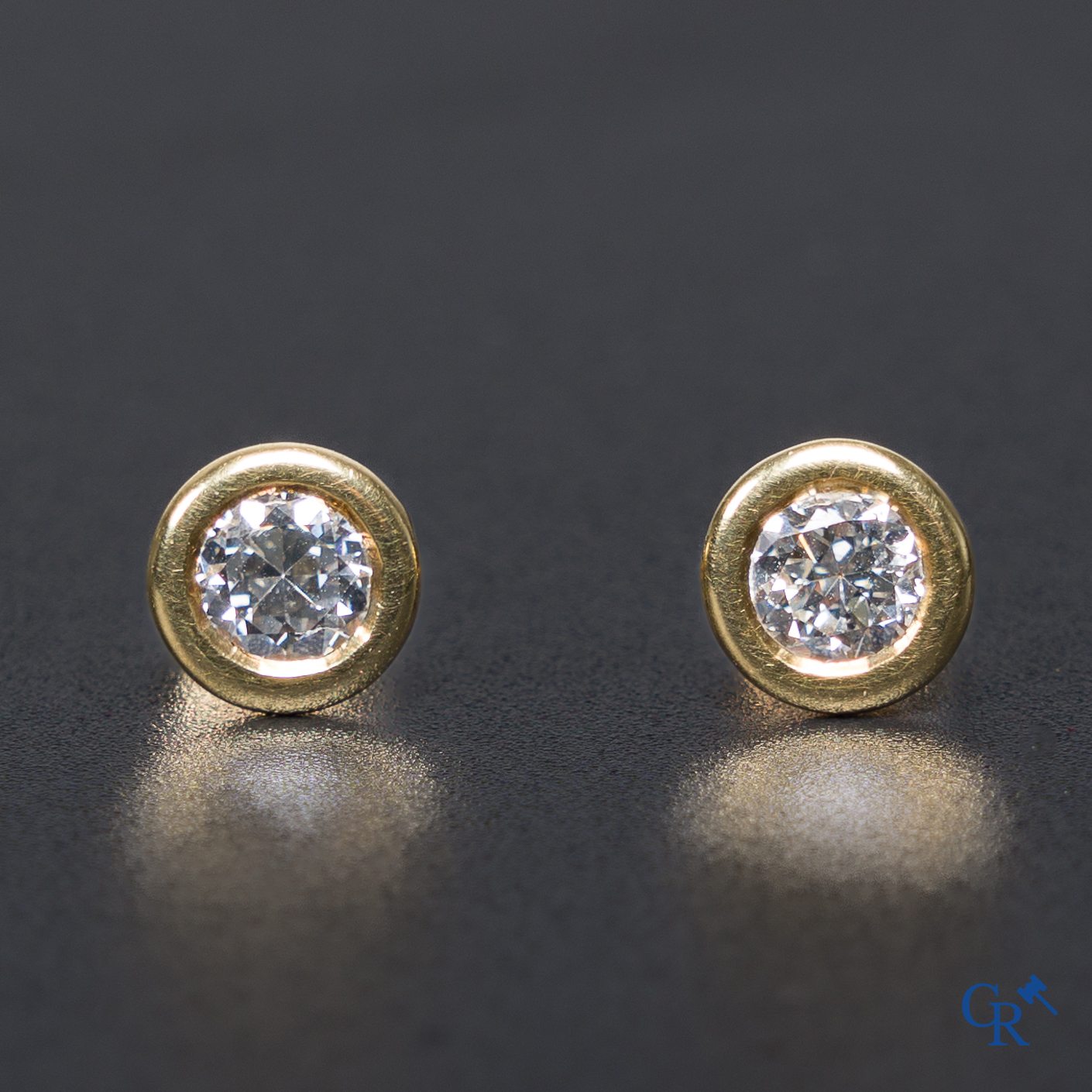 Bijoux: Une paire de boucles d'oreilles en or 18K (750 °/00) serties de diamants.