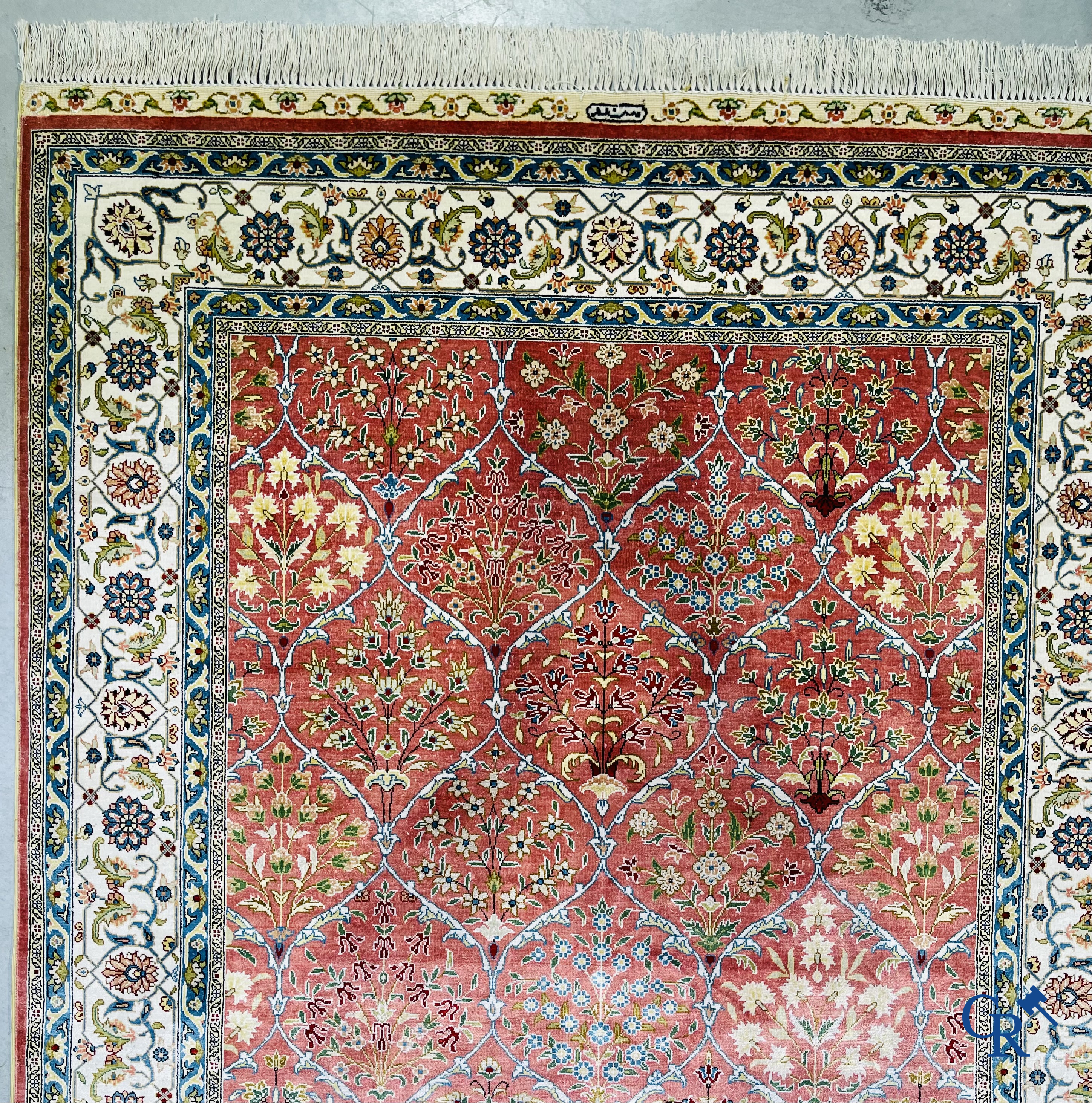 Tapis d'Orient: Un tapis finement noué à la main en laine et soie avec un décor floral.<br />
Signé.