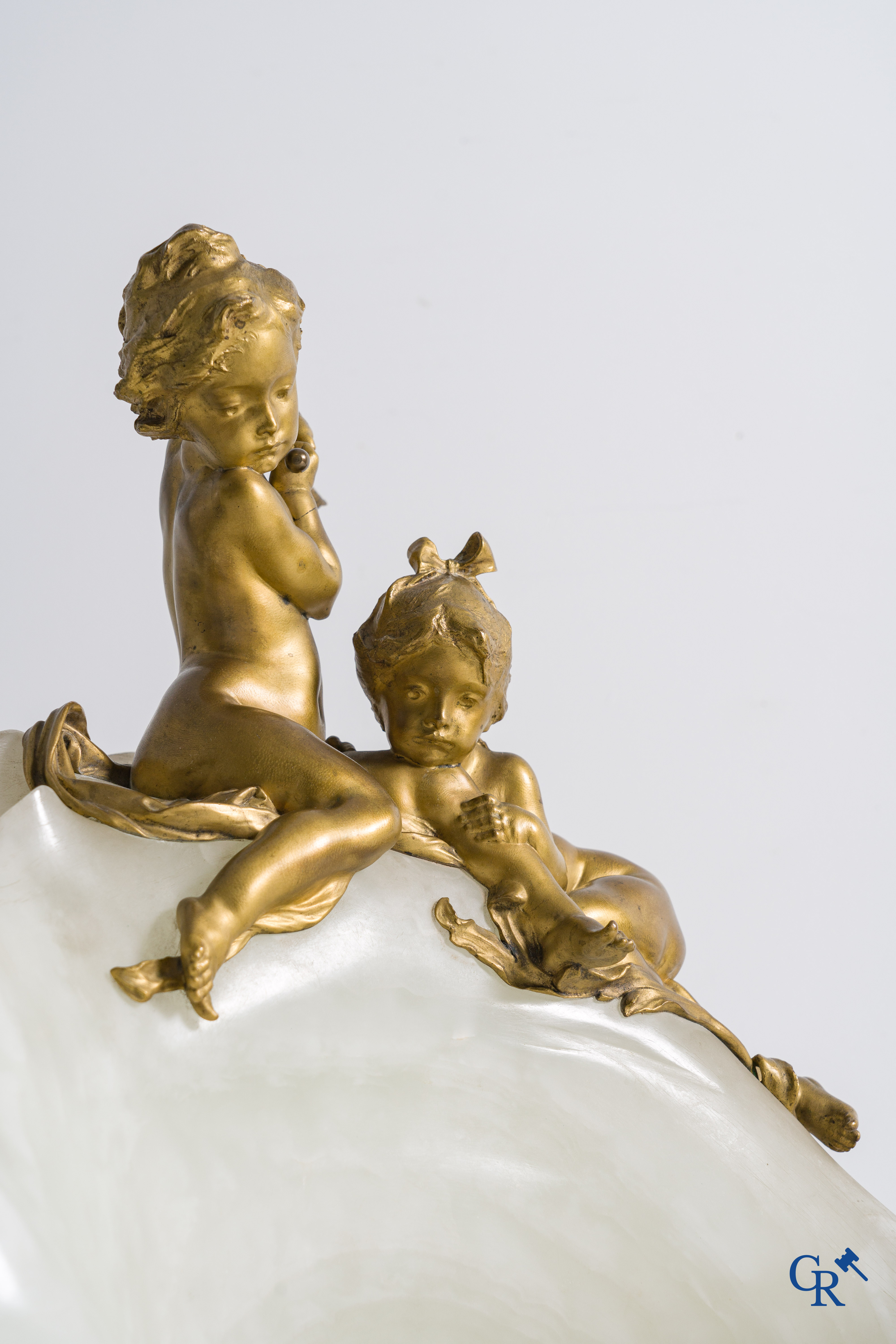 Henri Pernot (1859 - 1937) Spelende putti op een grote open zeeschelp. Witte onyx en vergulde brons. Circa 1900.