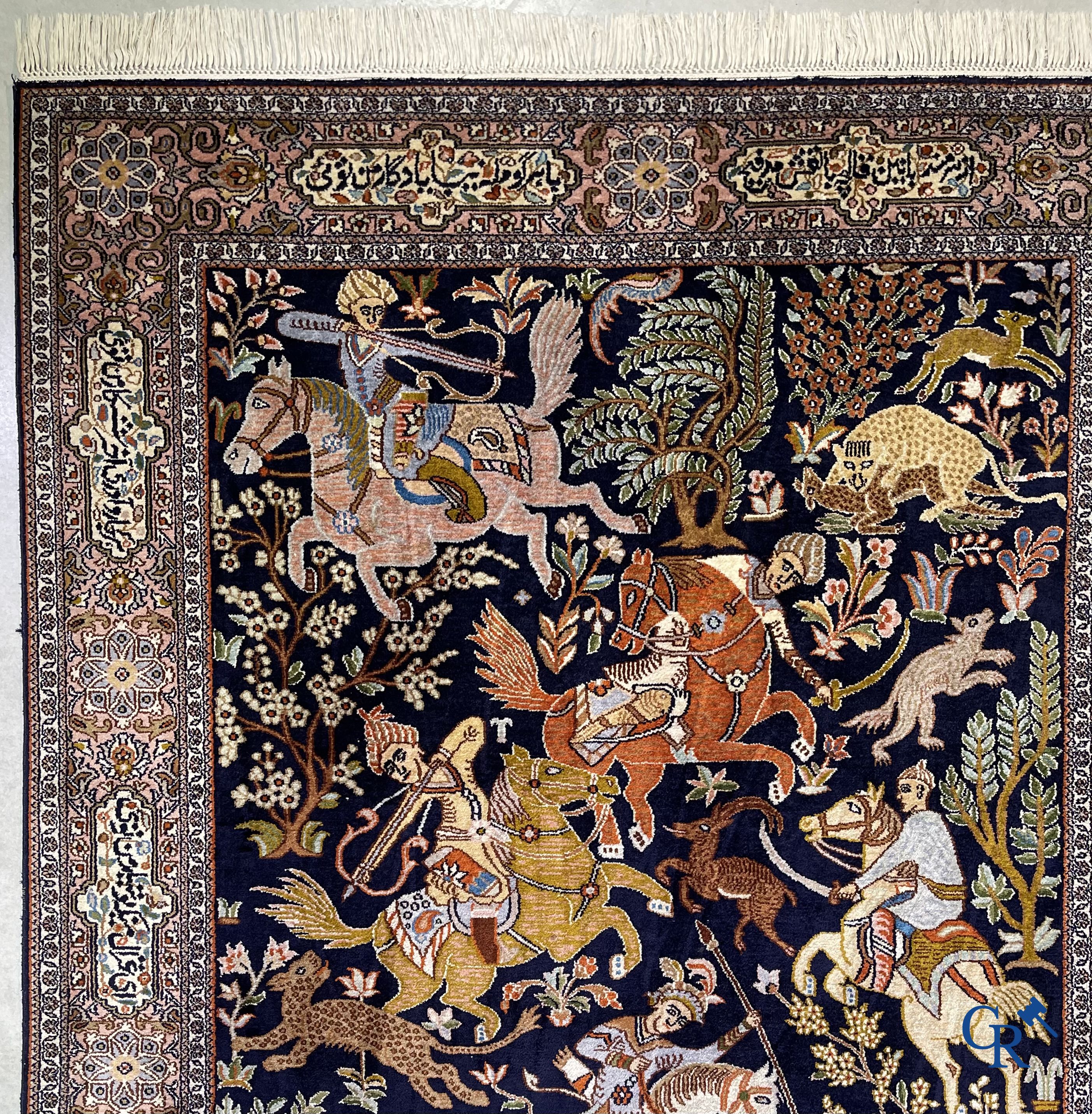 Oriental rugs. Iran. A finely hand-knotted Persian rug in wool and silk with hunters on horseback and inscriptions.