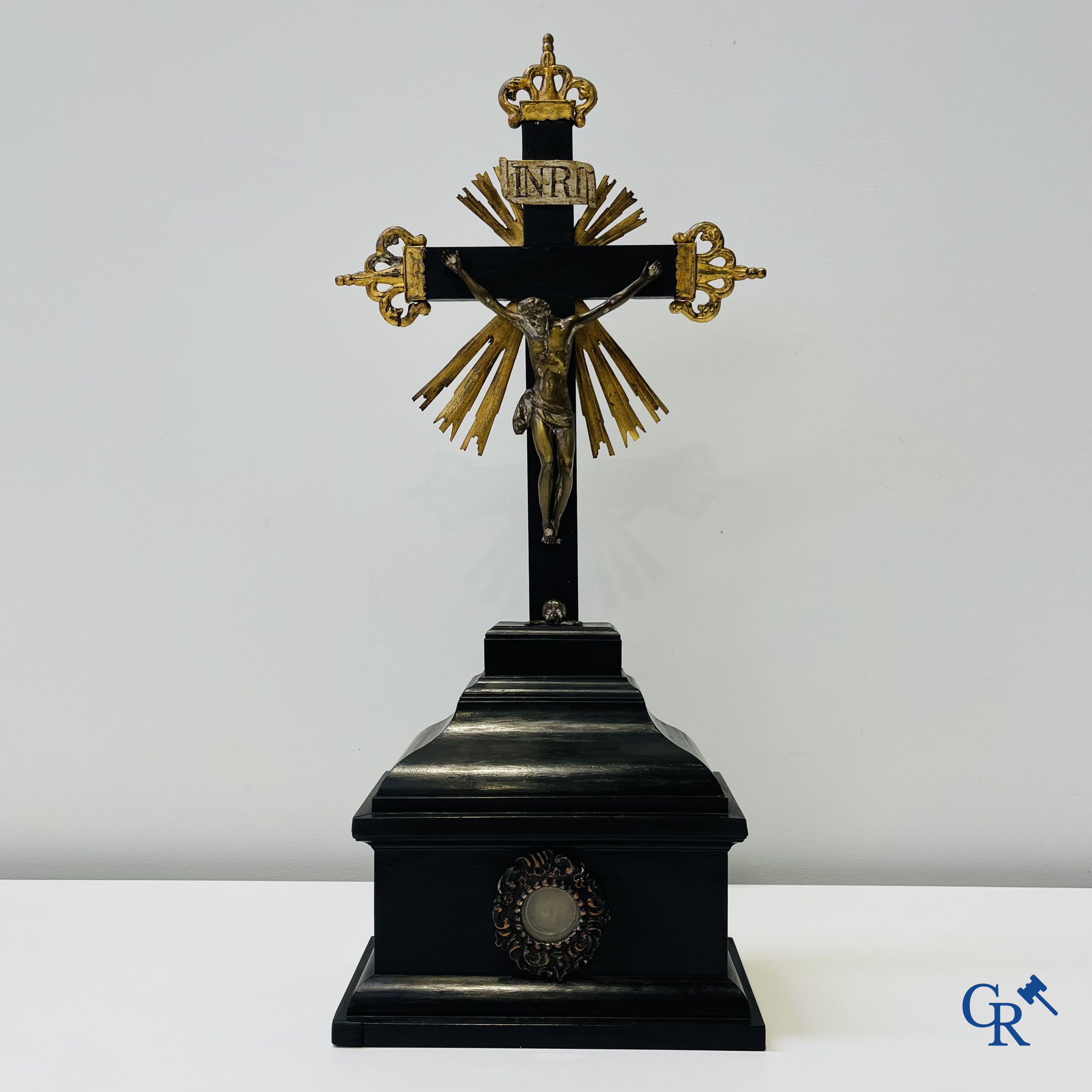 Religious objects: Bronze Christ on the cross held up by an ebony reliquary with relic.