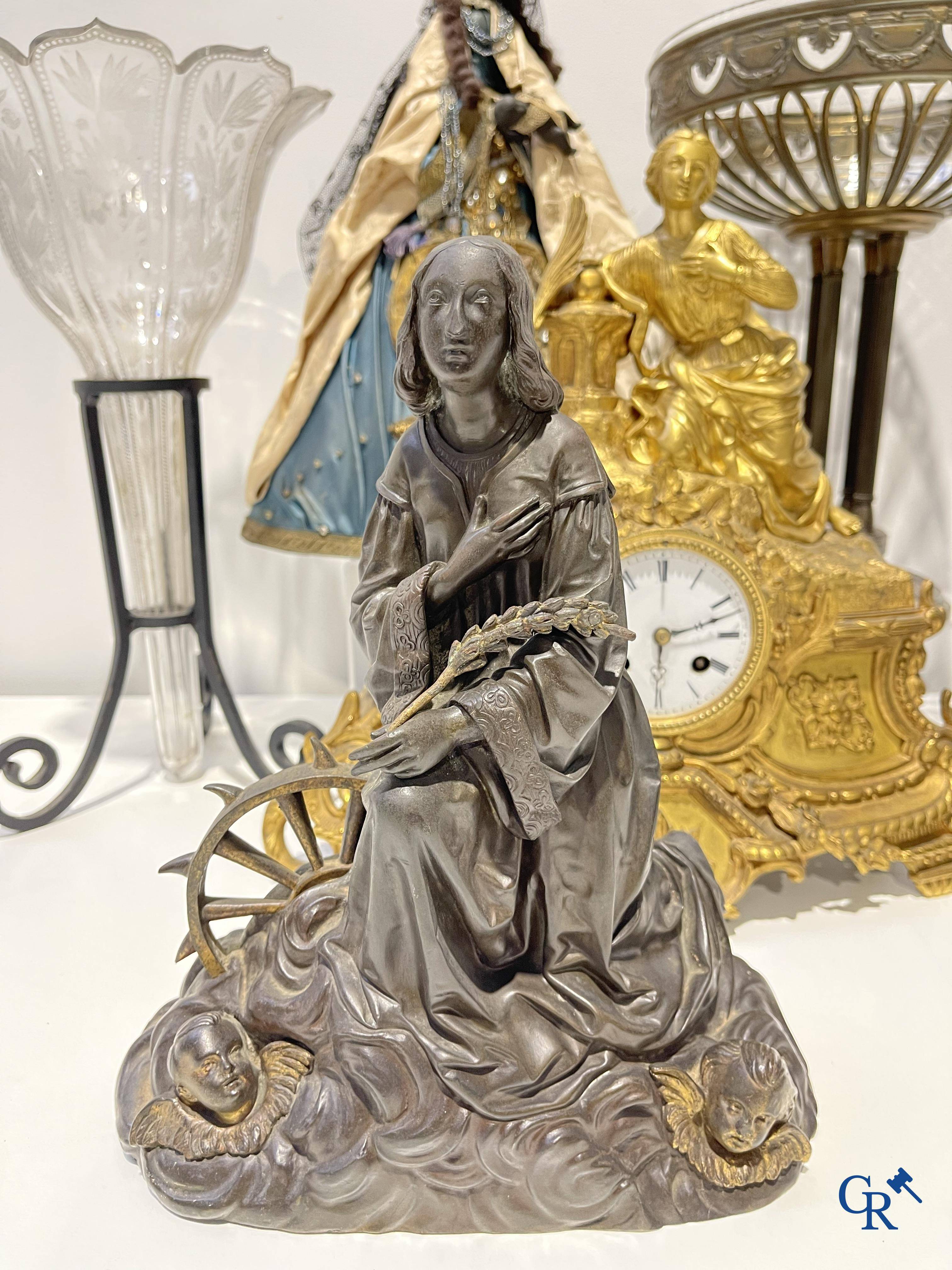 Een lot brocante: Bronzen schouwklok, bronzen neo gotische kandelaars en beeld St. Catharina, soliflore enz.