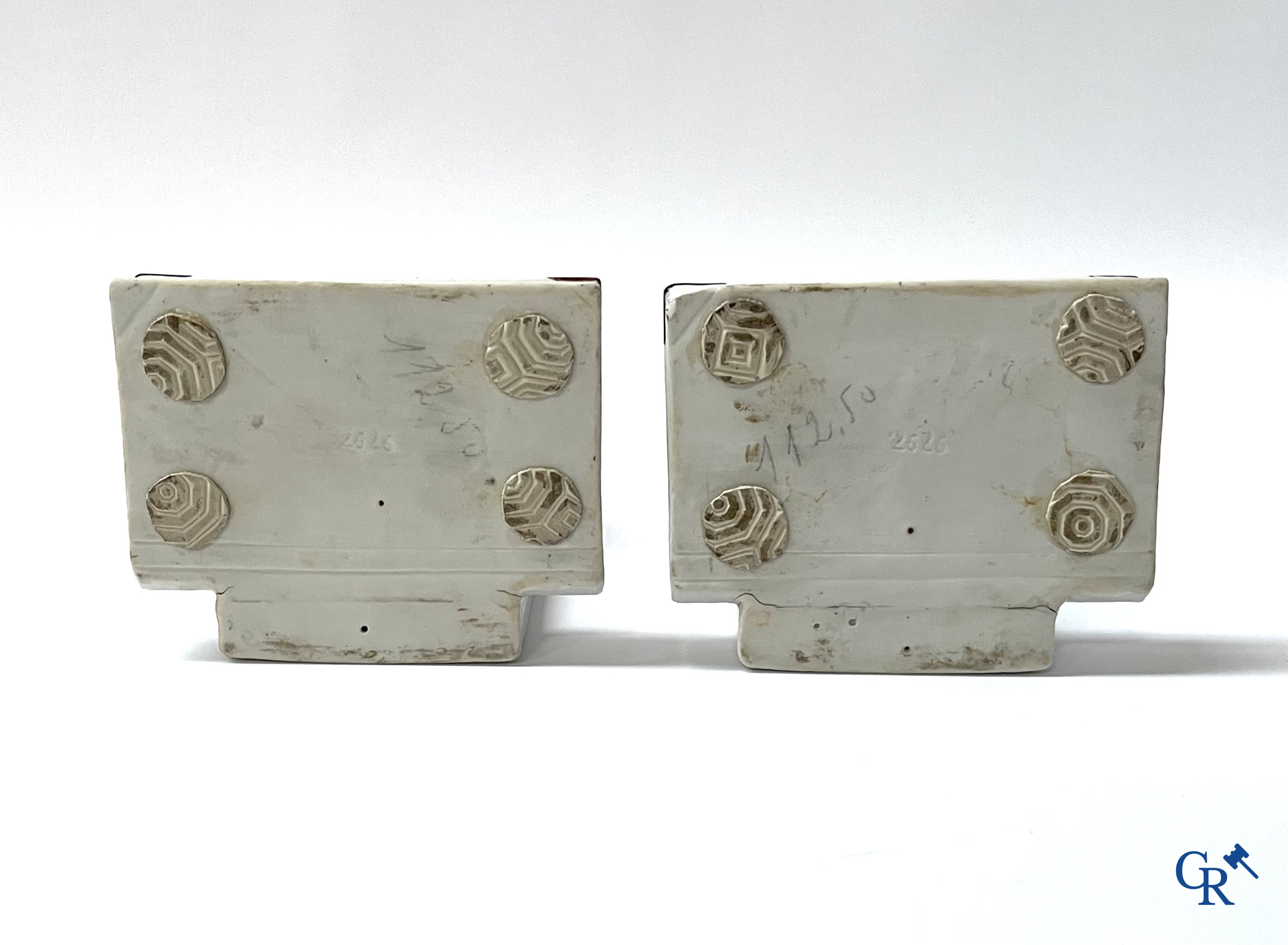 Art Deco, een paar boekensteunen in gepolychromeerd porselein met een typische Art deco voorstelling van maraboes.