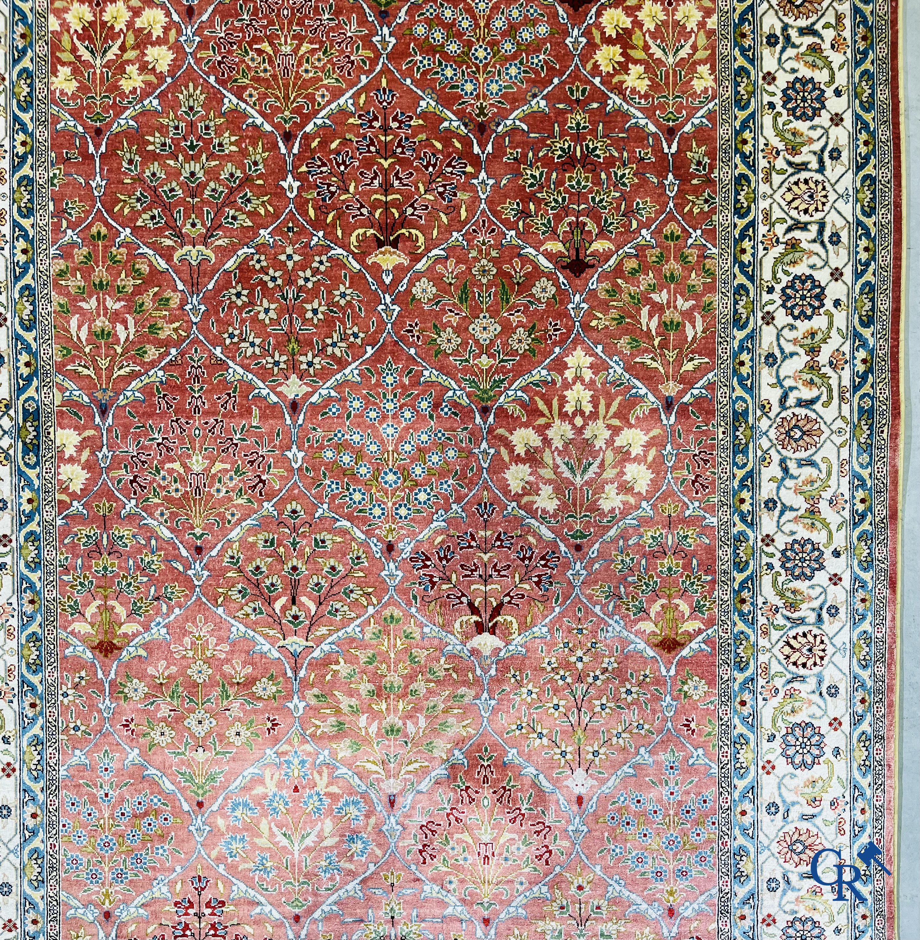 Tapis d'Orient: Un tapis finement noué à la main en laine et soie avec un décor floral.<br />
Signé.