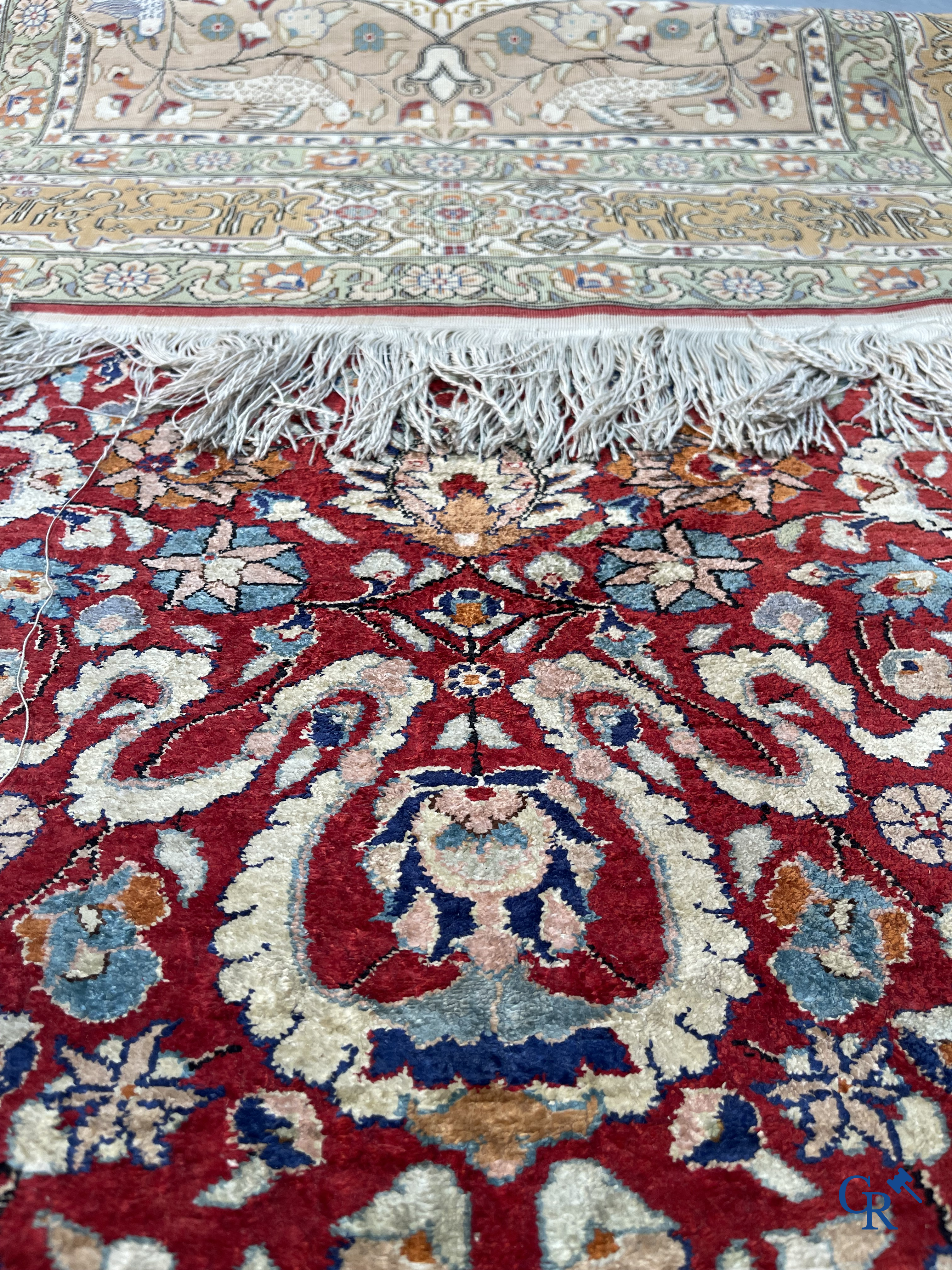 Oriental carpets: Hereke, a finely knotted silk carpet with inscriptions and birds in a floral decor.