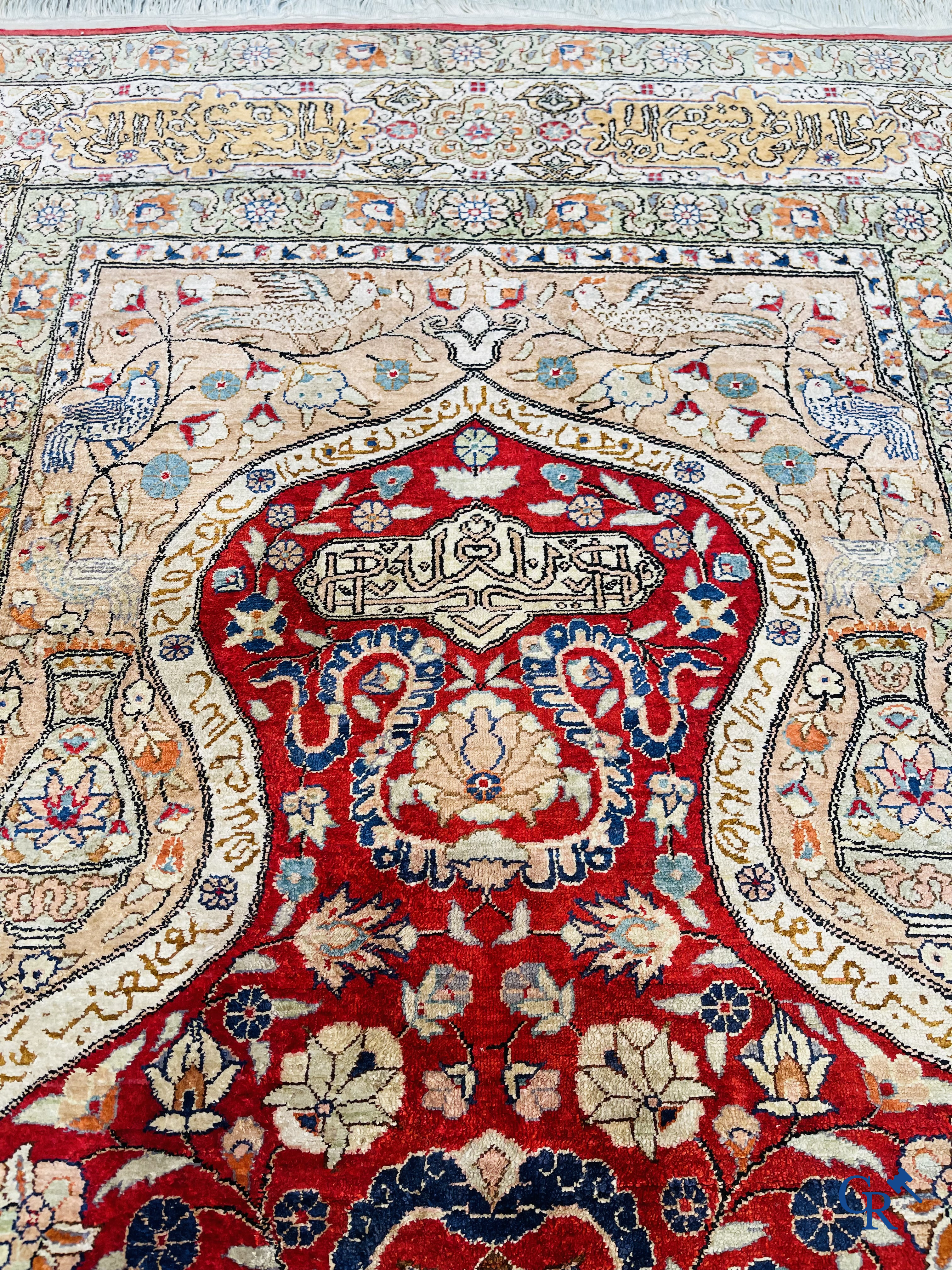 Oriental carpets: Hereke, a finely knotted silk carpet with inscriptions and birds in a floral decor.