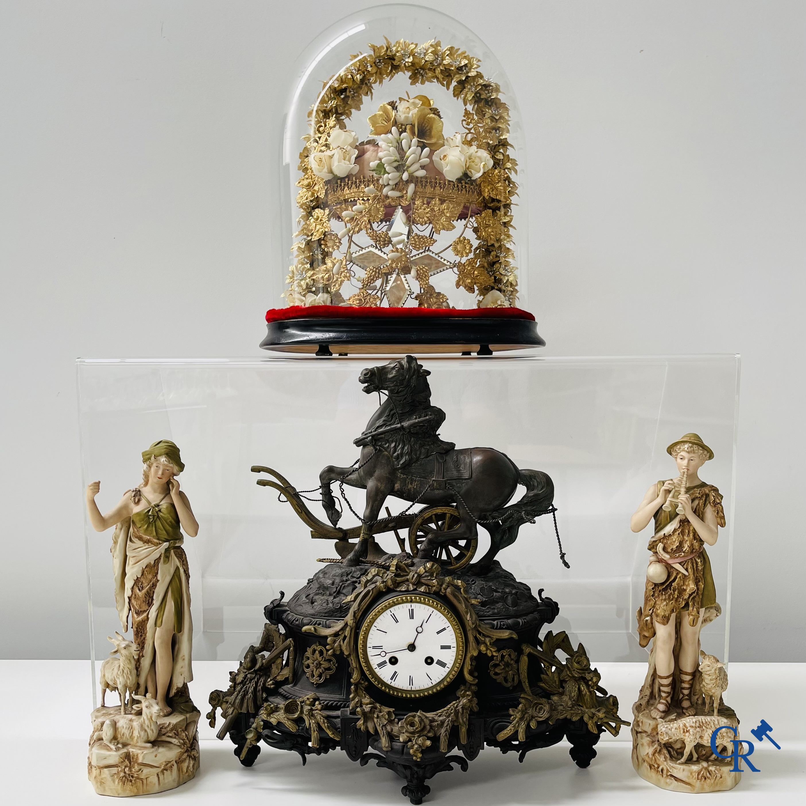 A lot with a clock in spelter, a pair of statues in Royal Dux and a french wedding dome globe.