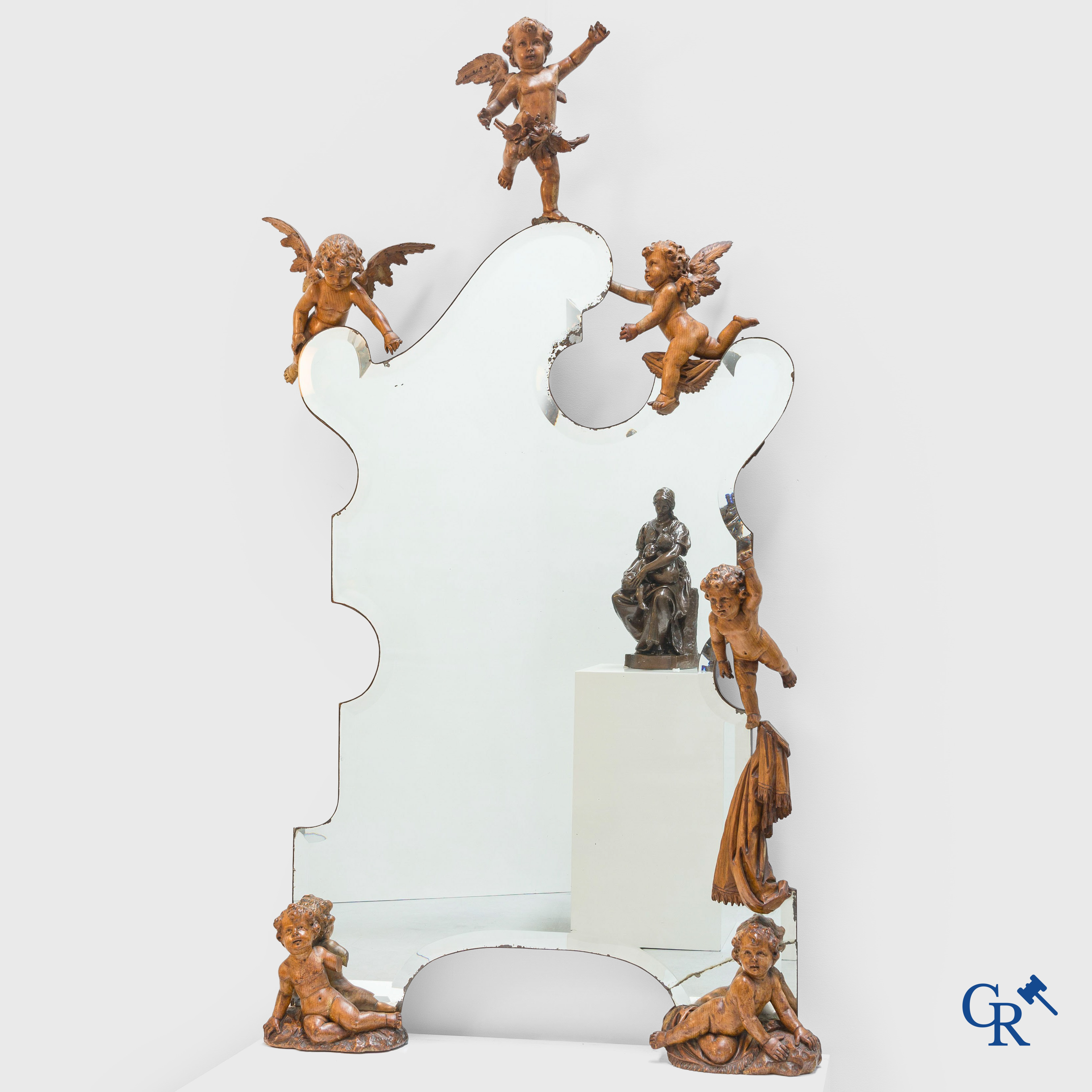 Un grand miroir entouré de 6 putti en bois sculpté. Vers 1900.