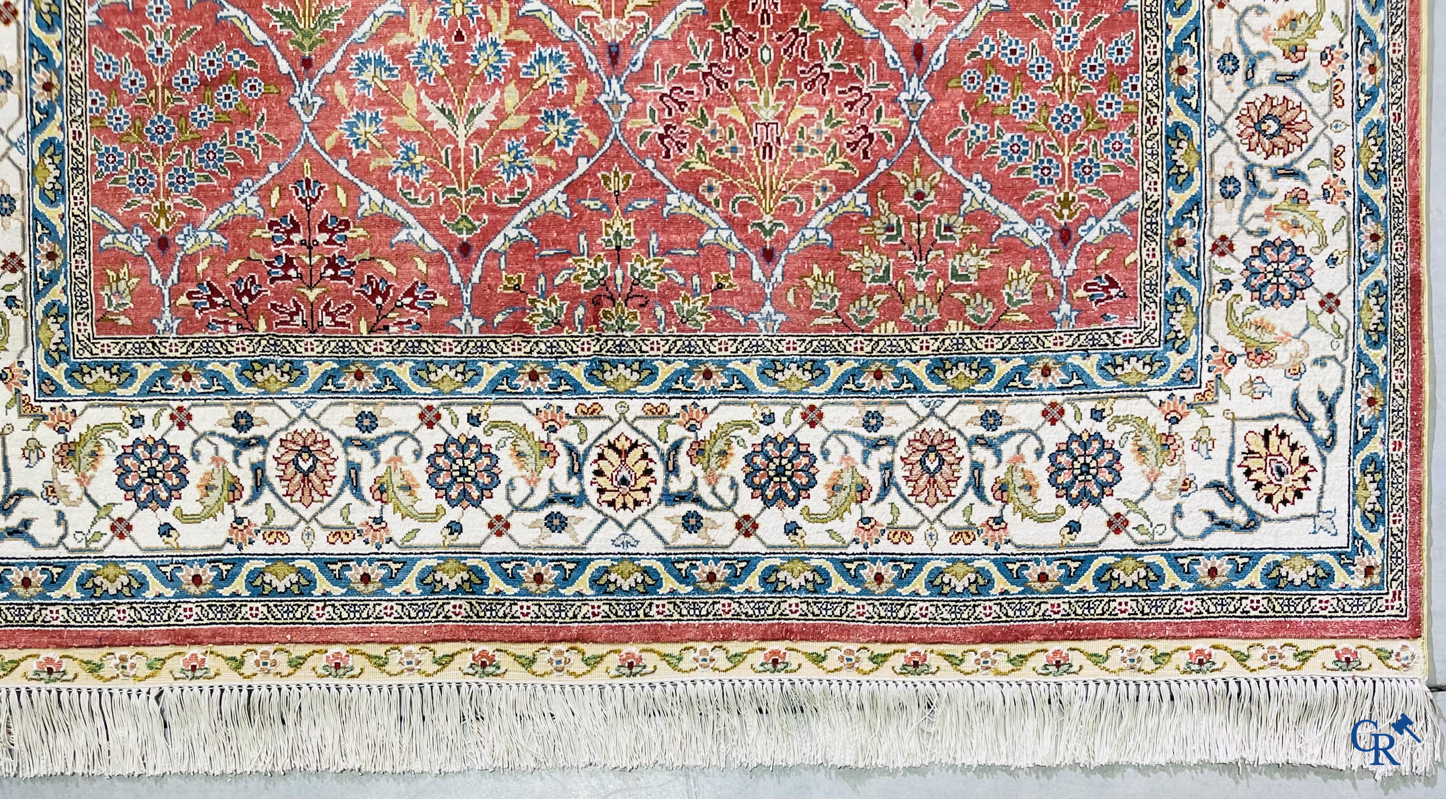 Tapis d'Orient: Un tapis finement noué à la main en laine et soie avec un décor floral.<br />
Signé.