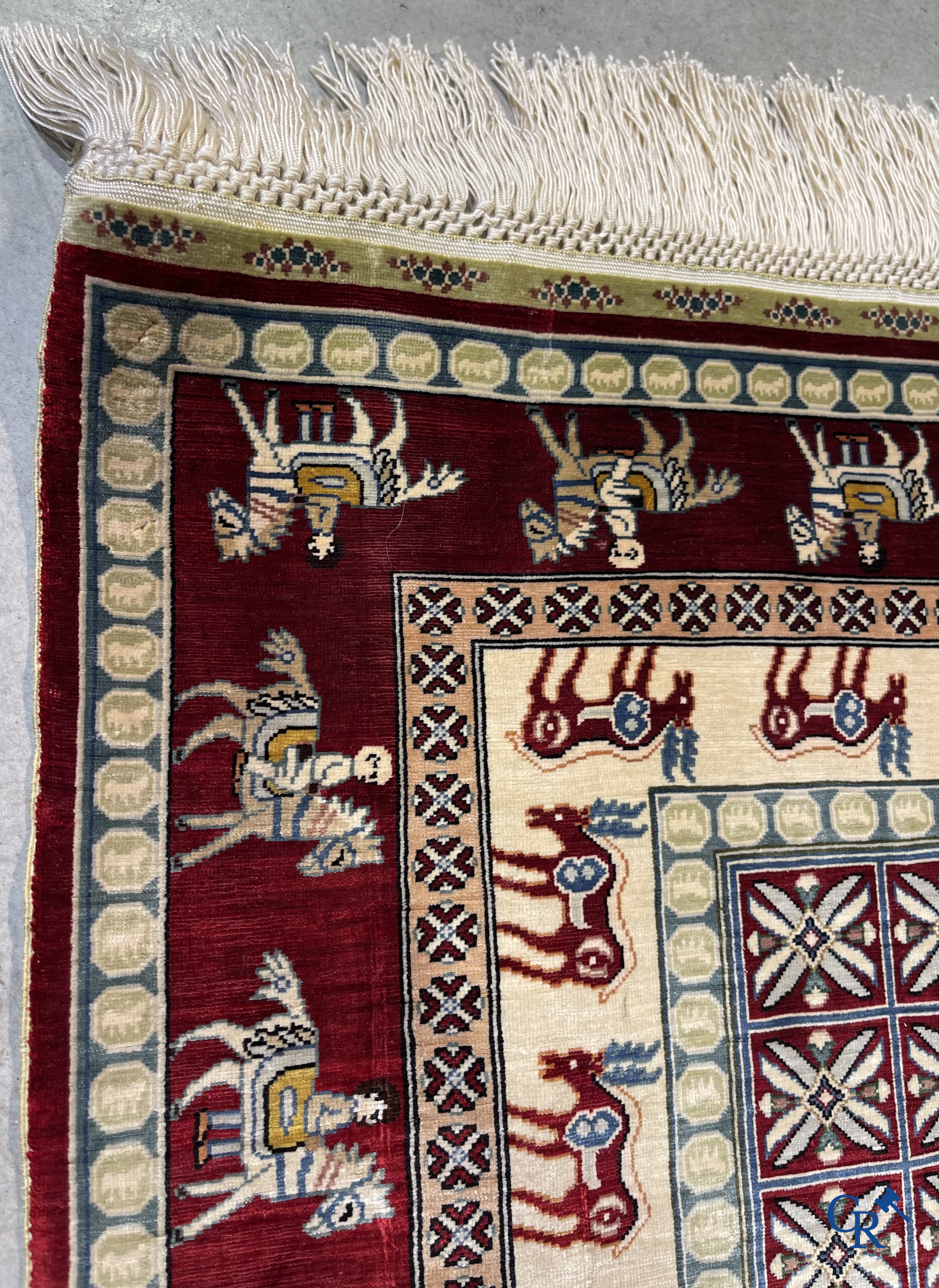 Oriental rugs: A small finely hand-knotted silk rug with deer and horsemen. Signed.