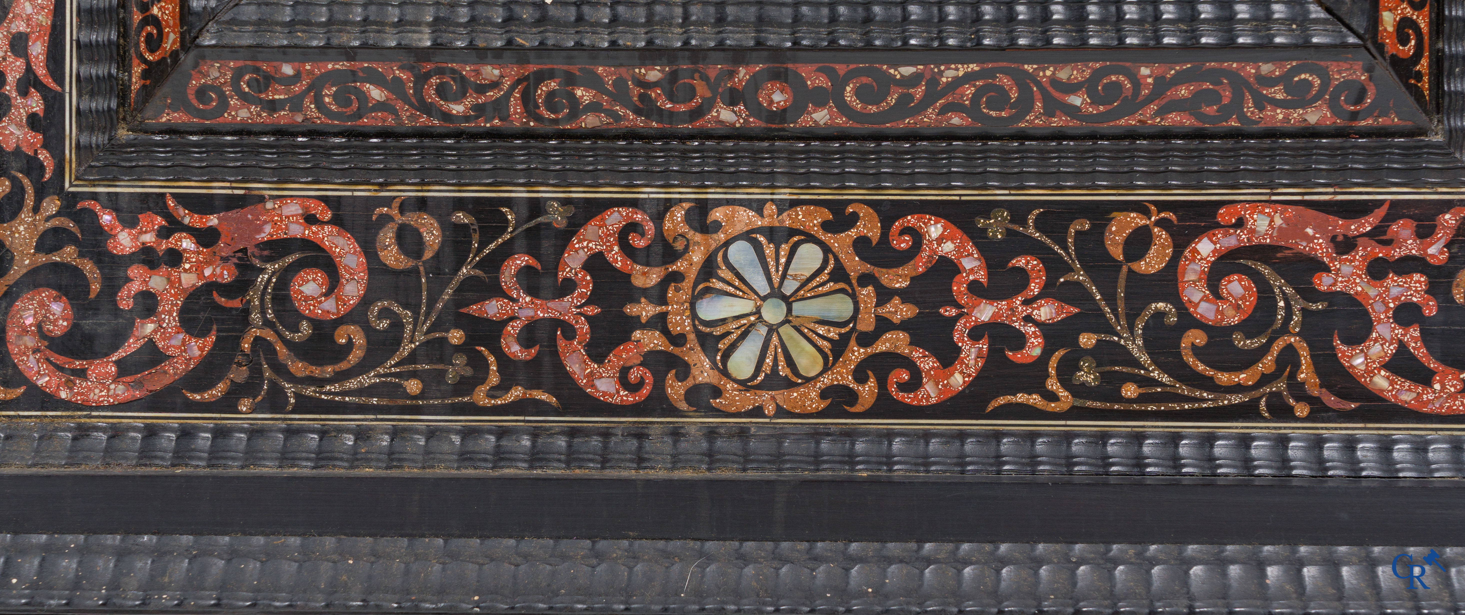 Een spiegel in ebbenhout en inlegwerk. 18e- 19e eeuw.