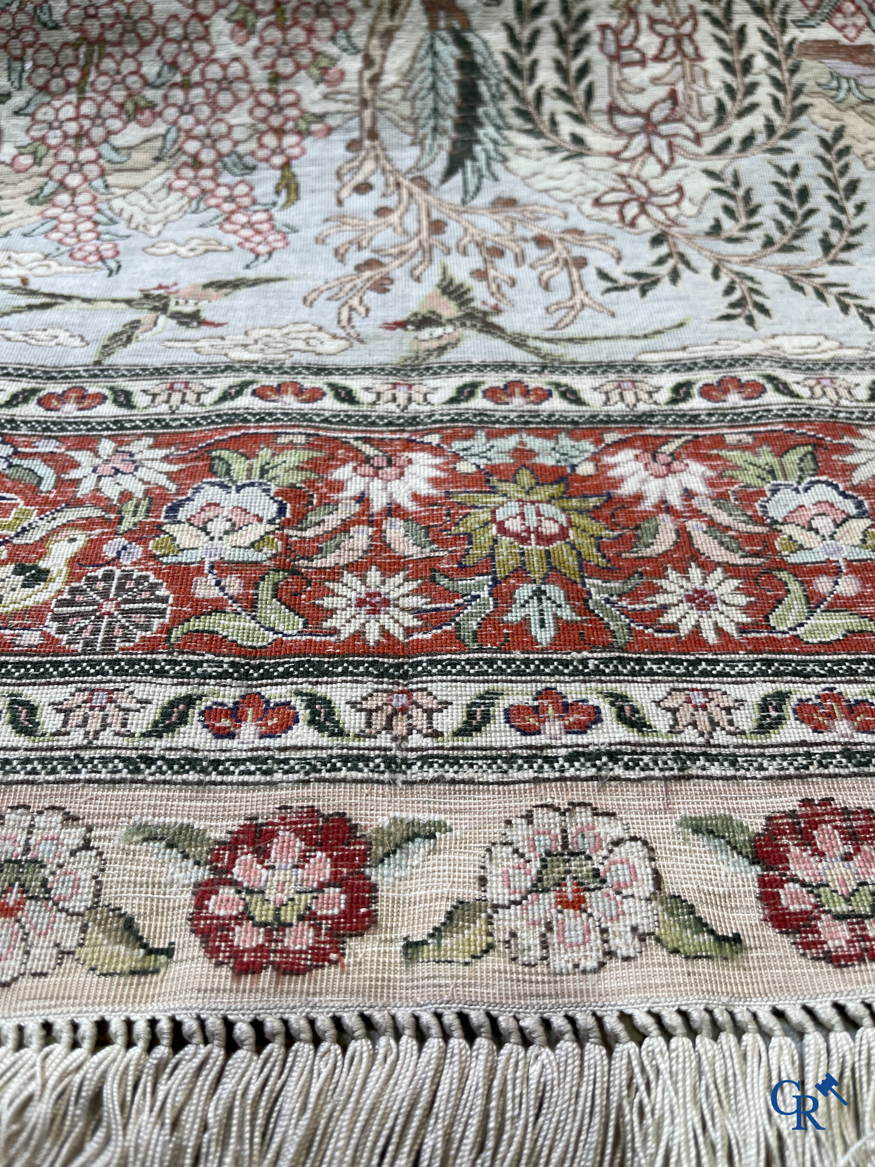 Oriental carpets: A finely hand-knotted silk carpet with water birds in a landscape on a floral background.