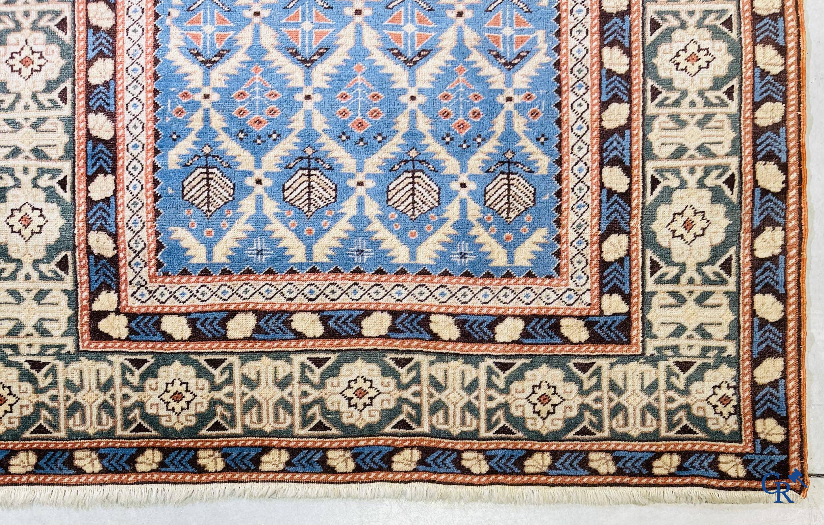 Antique Oriental carpets, an antique Dagestan carpet with motifs on a blue background.