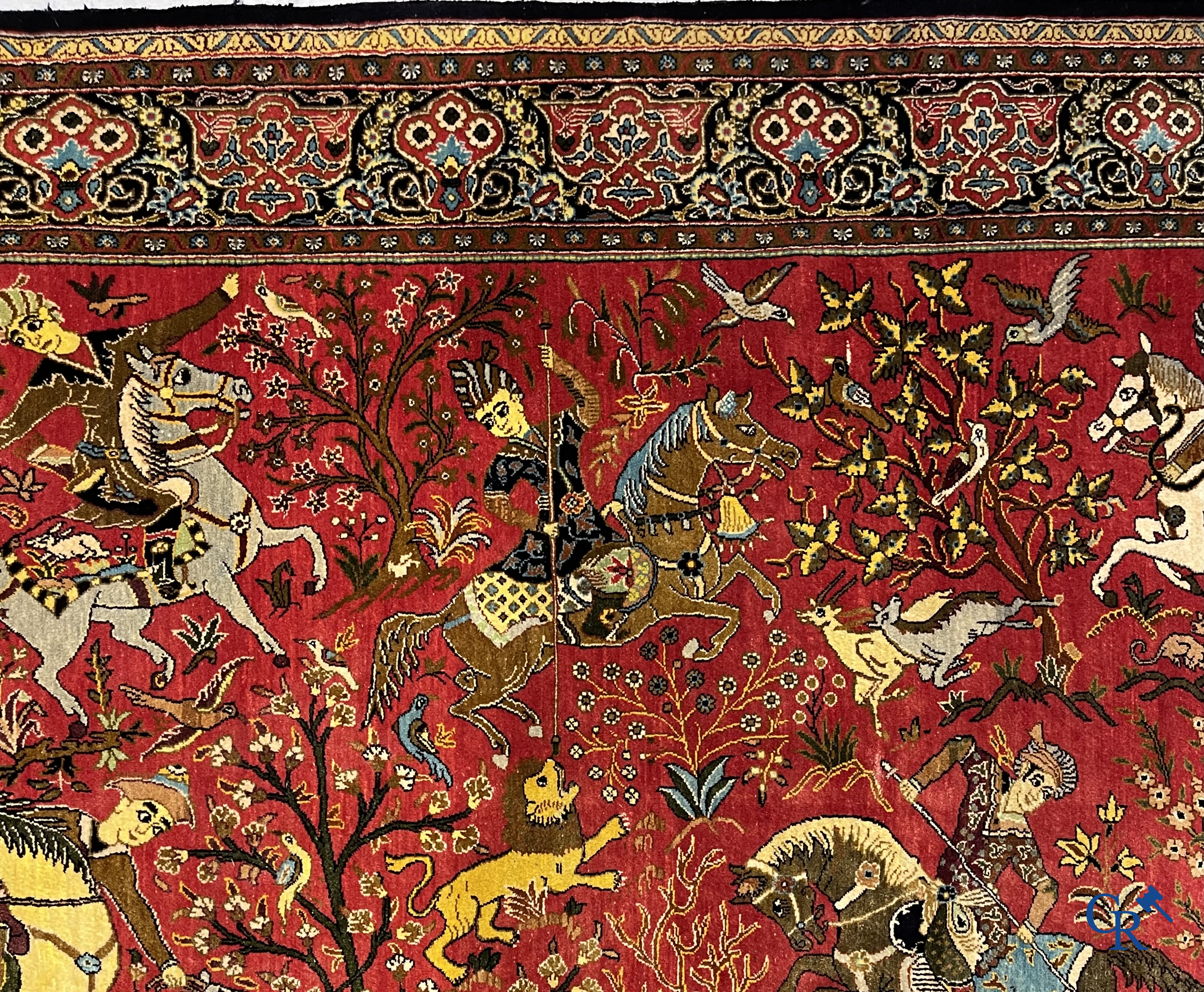 Oriental carpets, a Persian carpet in silk with a scene of hunters on horseback.