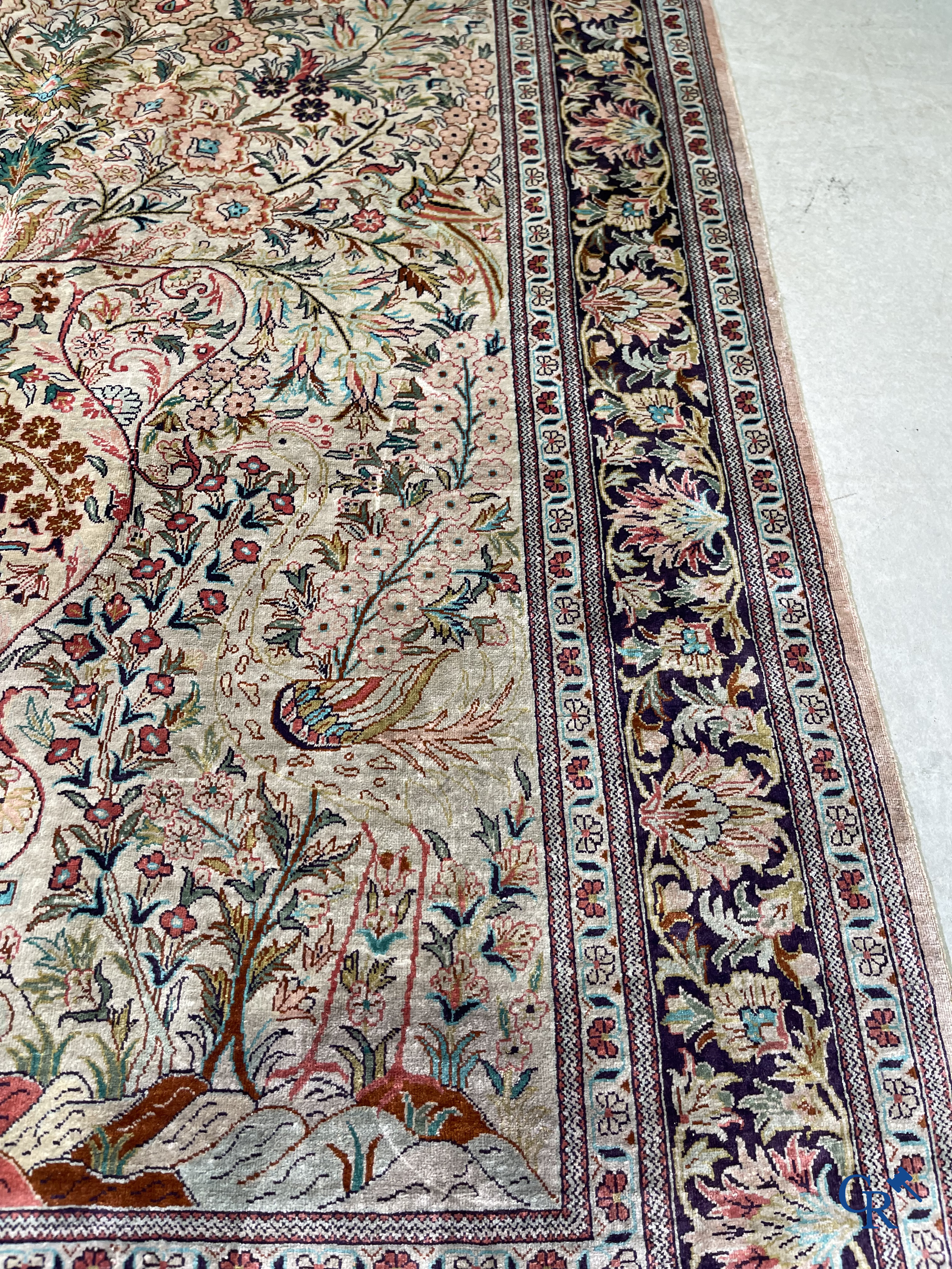 Tapis d'Orient: Un tapis persan en soie finement noué à la main avec un vase à fleurs et des oiseaux dans un décor floral.