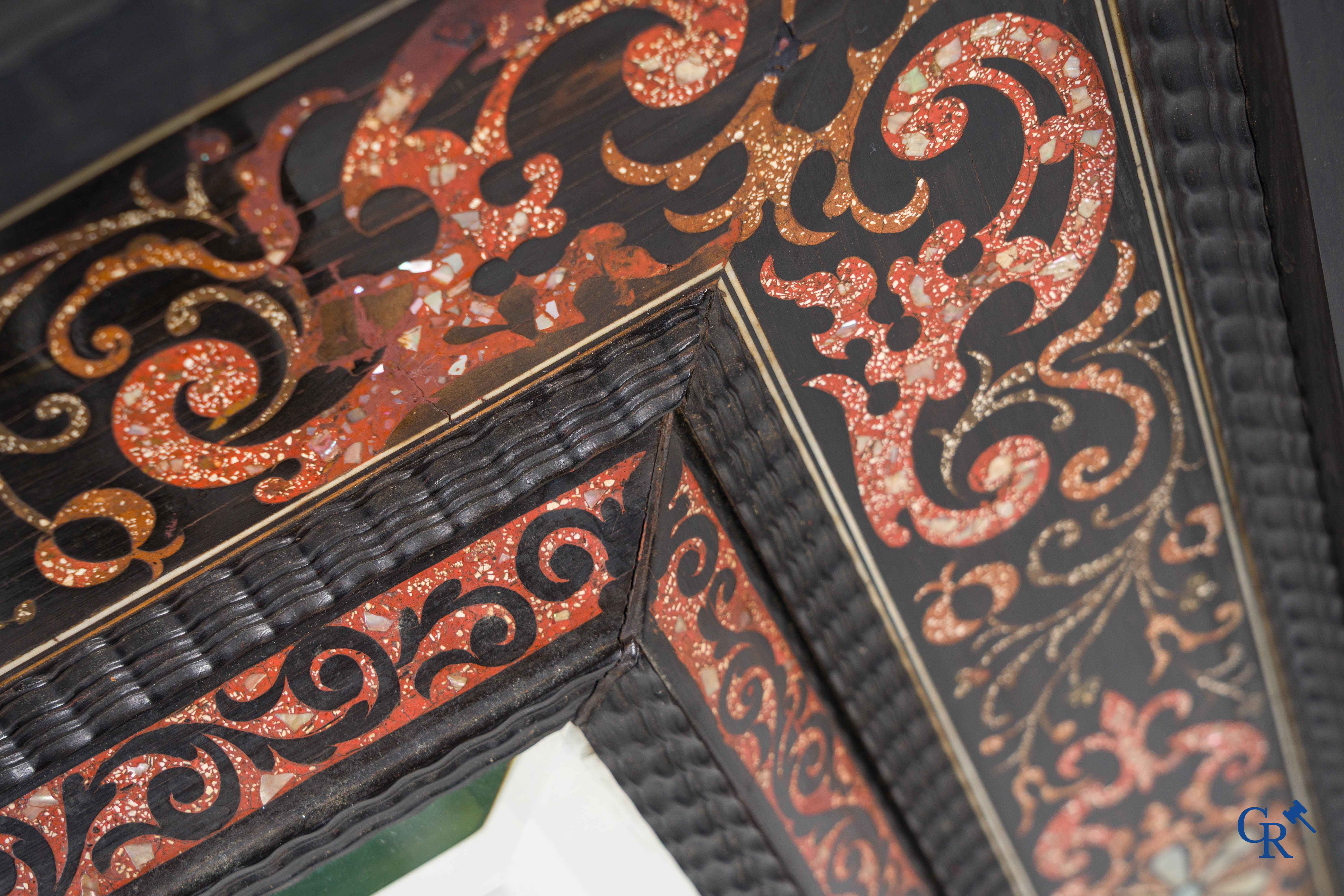 Een spiegel in ebbenhout en inlegwerk. 18e- 19e eeuw.