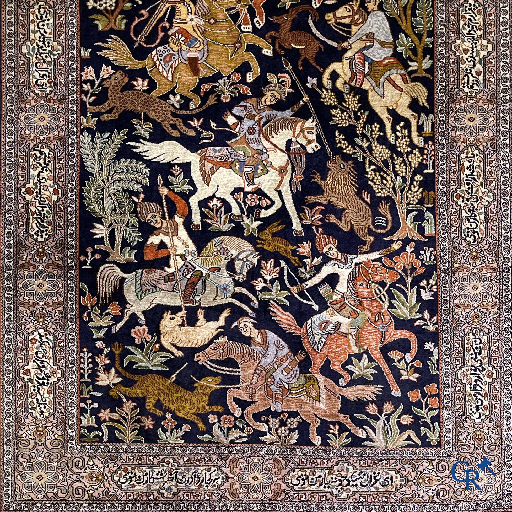 Oriental rugs. Iran. A finely hand-knotted Persian rug in wool and silk with hunters on horseback and inscriptions.