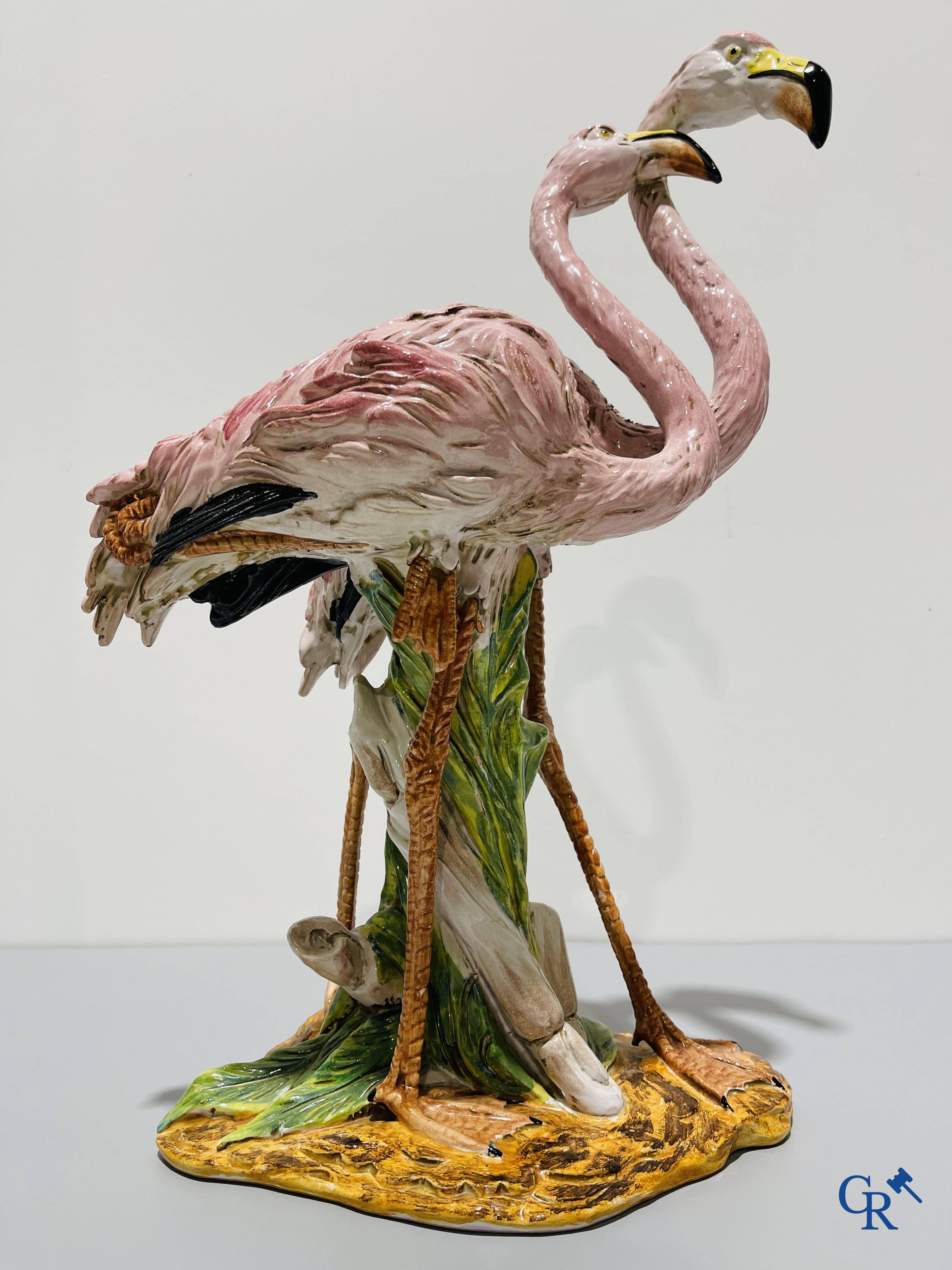 Een paar flamingo's in majolica in de stijl van Massier.