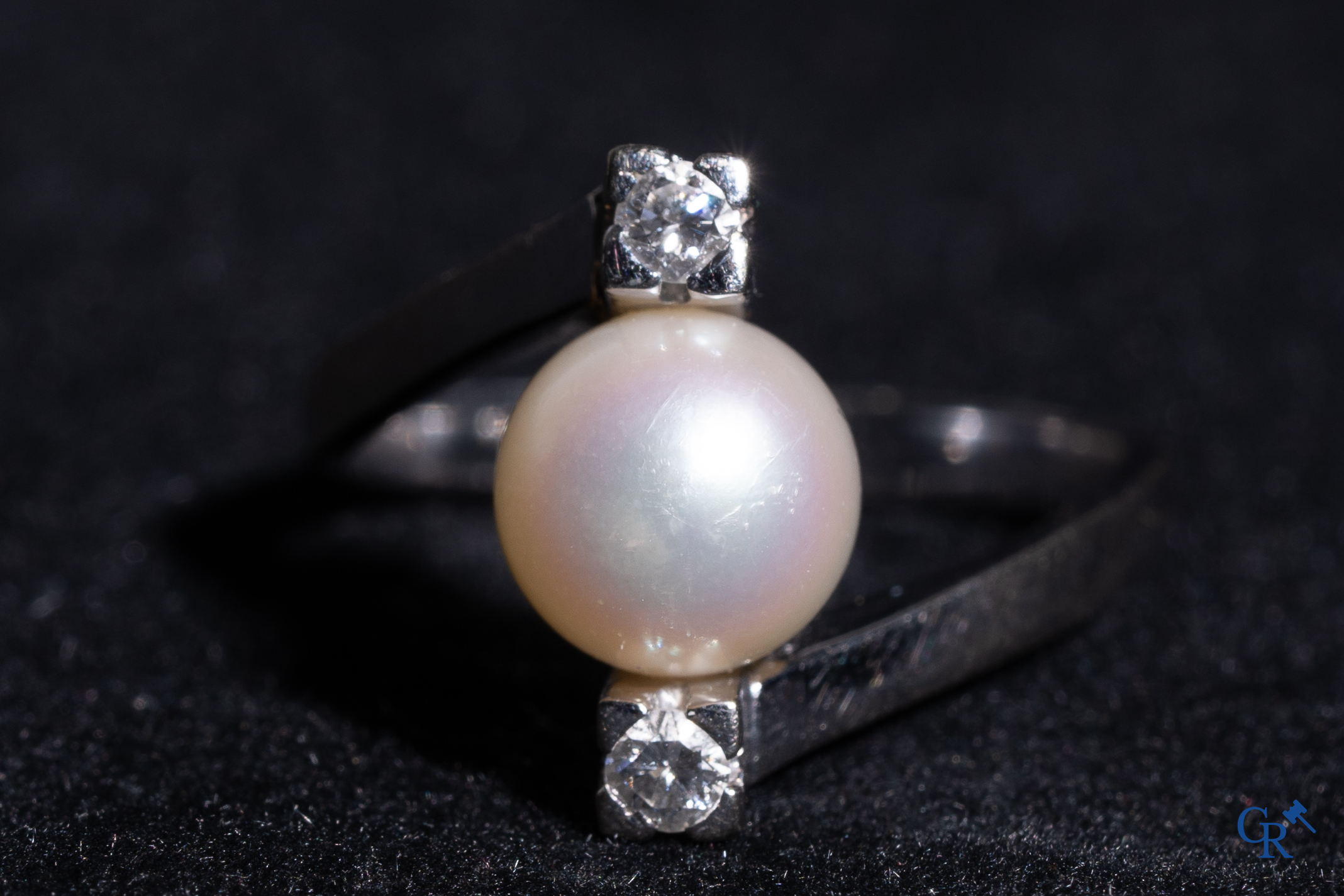 Bijoux: Une bague et une paire de boucles d'oreilles en or blanc 18K (750°/00) serties chacune d'une perle et de diamants.