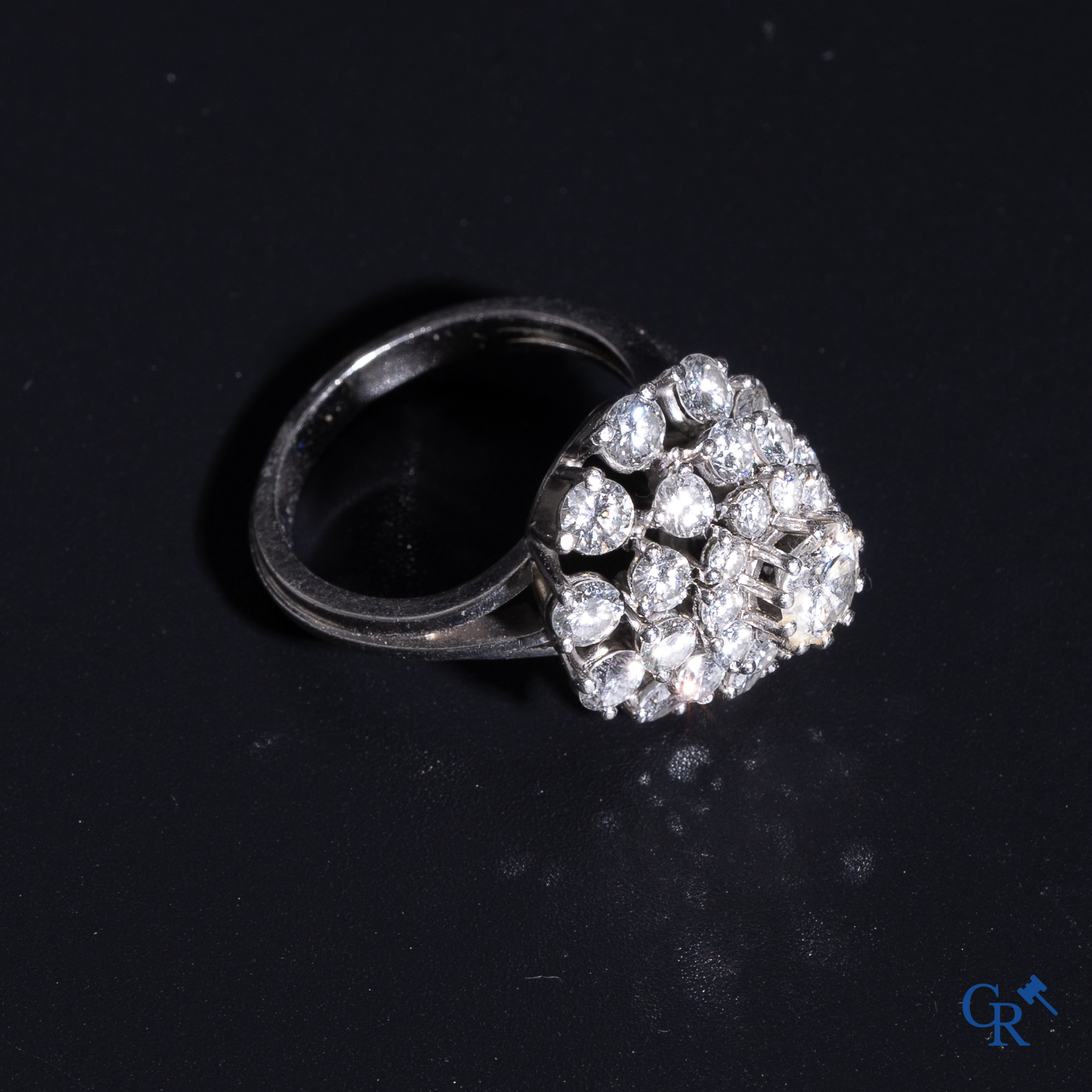 Juwelen: Pompadour ring in Platinum bezet met een centrale diamant van ongeveer 0,75 ct en 30 kleine diamantjes.