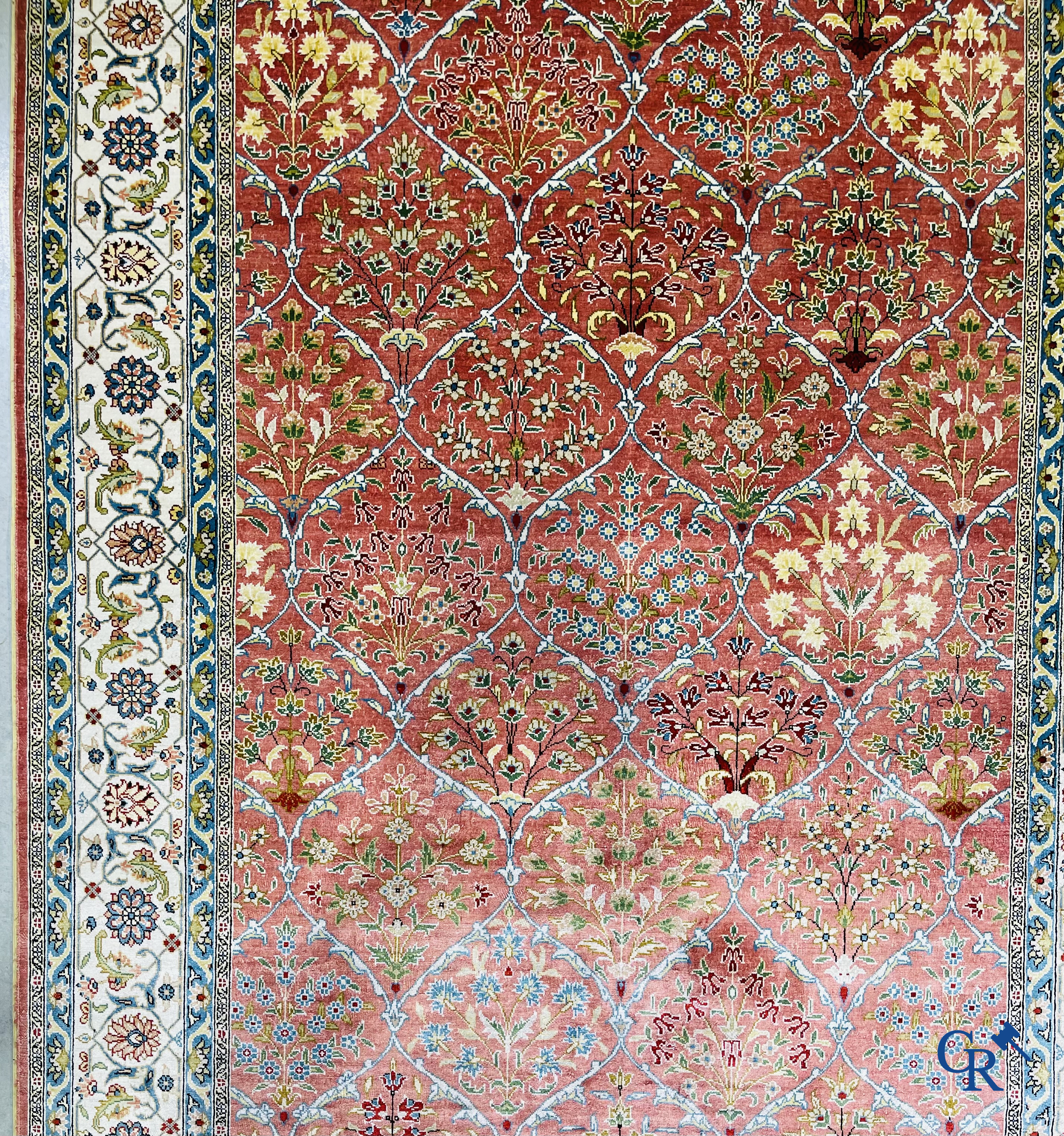 Tapis d'Orient: Un tapis finement noué à la main en laine et soie avec un décor floral.<br />
Signé.