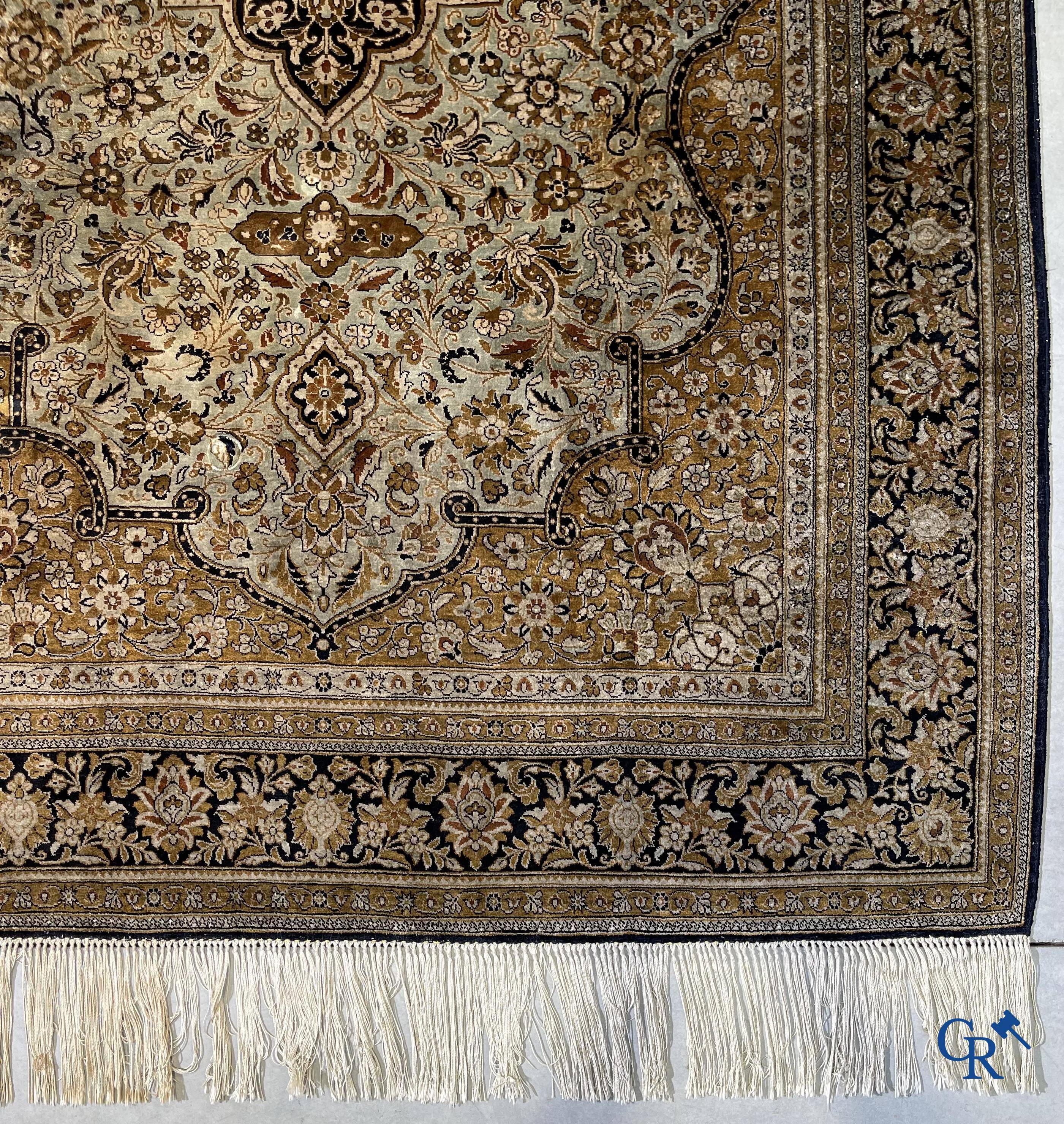 Tapis d'Orient. Un tapis en soie finement noué à la main avec un décor floral.