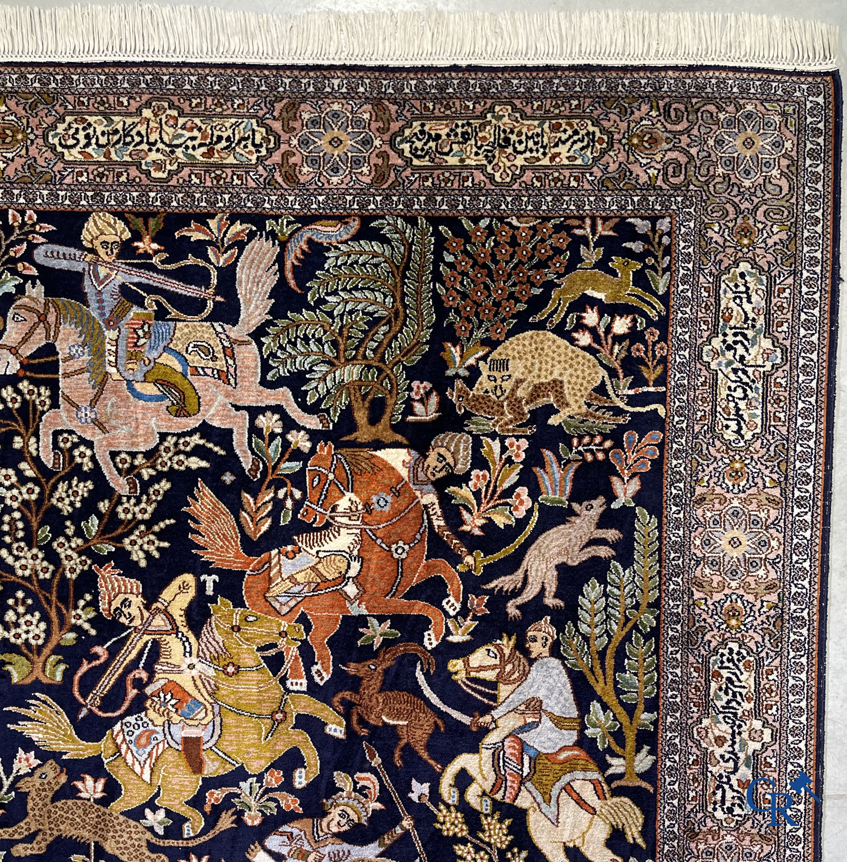 Oriental rugs. Iran. A finely hand-knotted Persian rug in wool and silk with hunters on horseback and inscriptions.